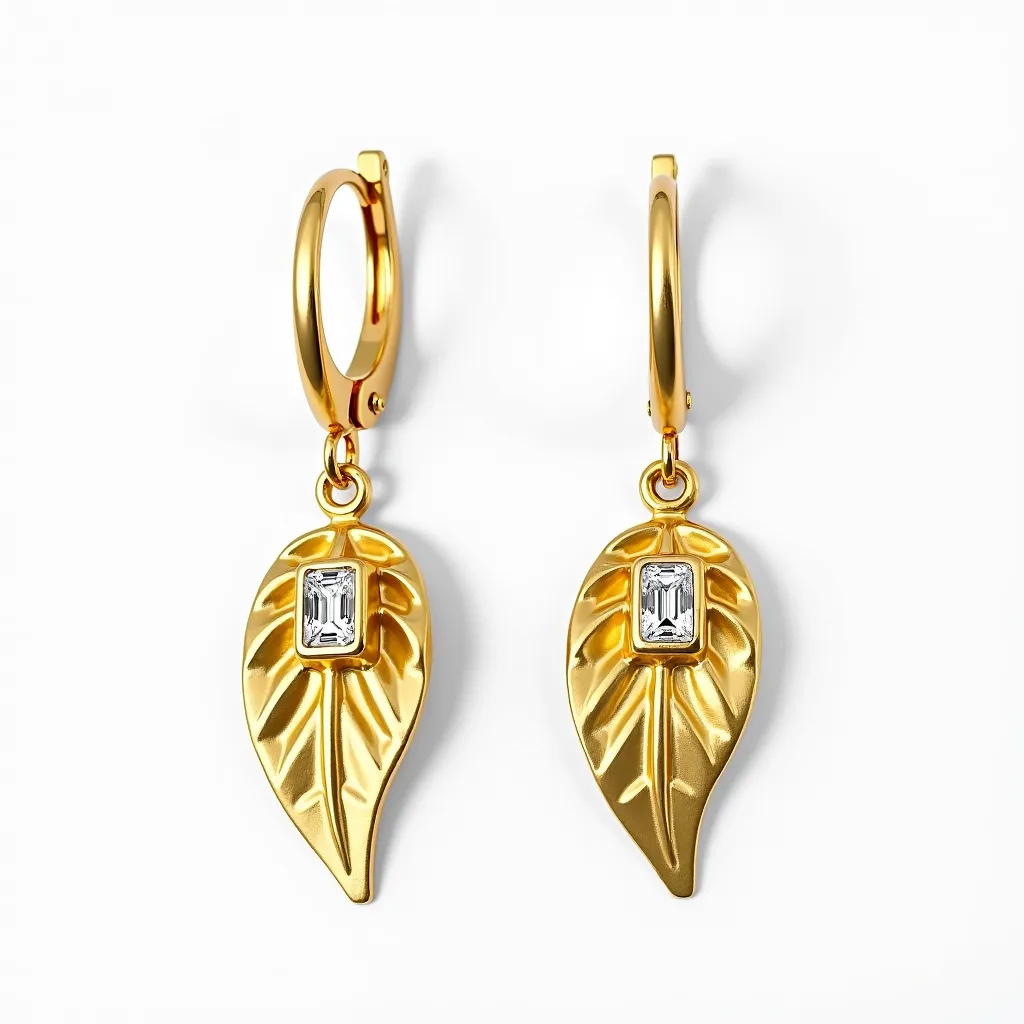 These hanging earrings feature a striking leaf design crafted from a gold-toned metal. Each earring is adorned with a single rectangular-cut gemstone that is set in the center of the leaf, adding an elegant sparkle. The stone is likely a clear, faceted gem that complements the intricate detailing of the leaf design. The earrings are attached to small, smooth hoops that appear to utilize a hinged clasp mechanism for secure and comfortable wear. The combination of the lustrous metal and the sparkling gemstone gives these earrings a sophisticated and stylish appearance.