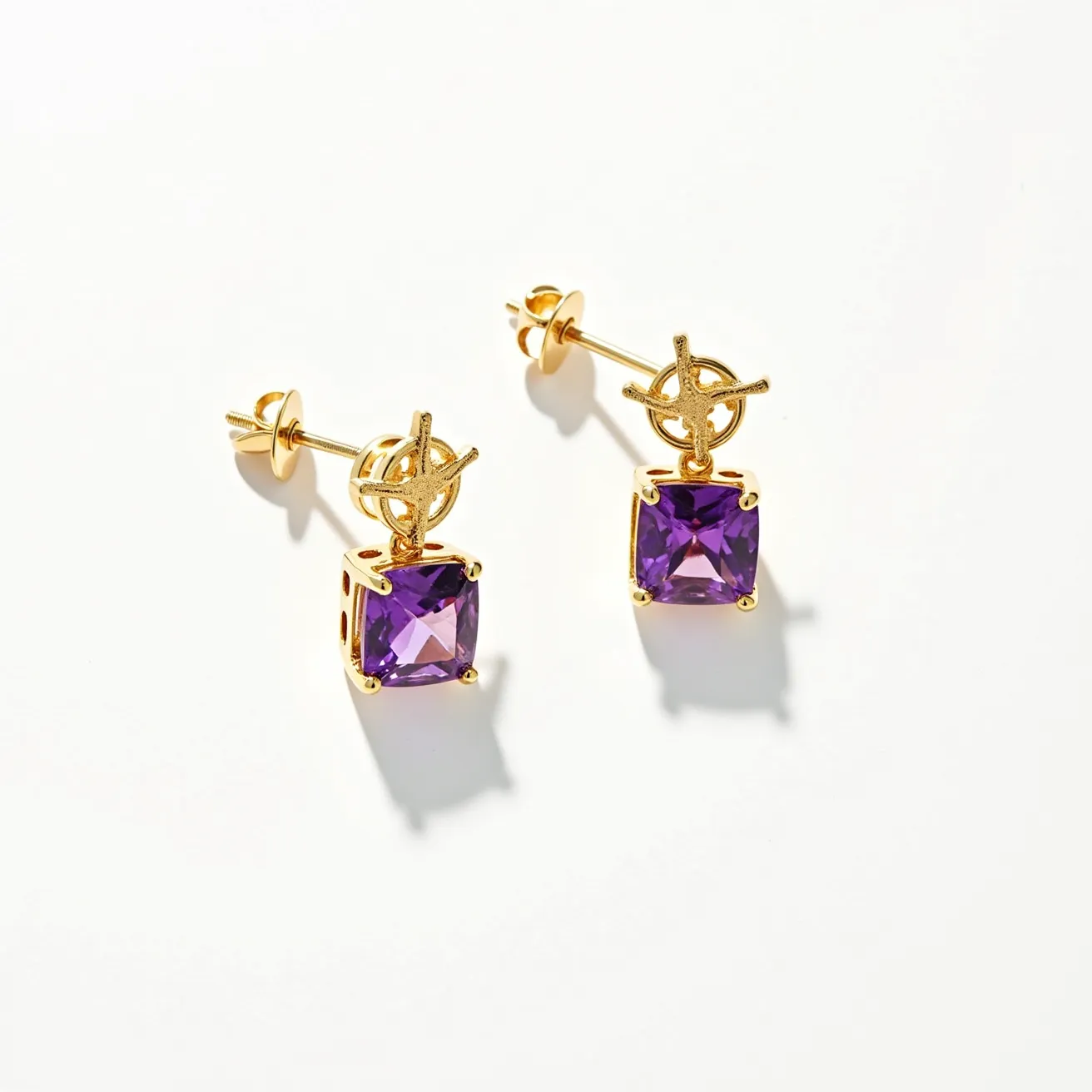 These hanging earrings feature a vibrant purple square-cut gemstone likely set in a four-prong gold setting, giving it an elegant and secure presentation. The gemstone dangles gracefully from a distinctive gold motif that resembles an intricate geometric or nautical design, adding a touch of sophistication. The attachment style is a post-back, providing a sturdy and convenient fastening for the wearer. The lustrous gold material complements the deep hue of the gemstone beautifully, enhancing its overall aesthetic appeal.