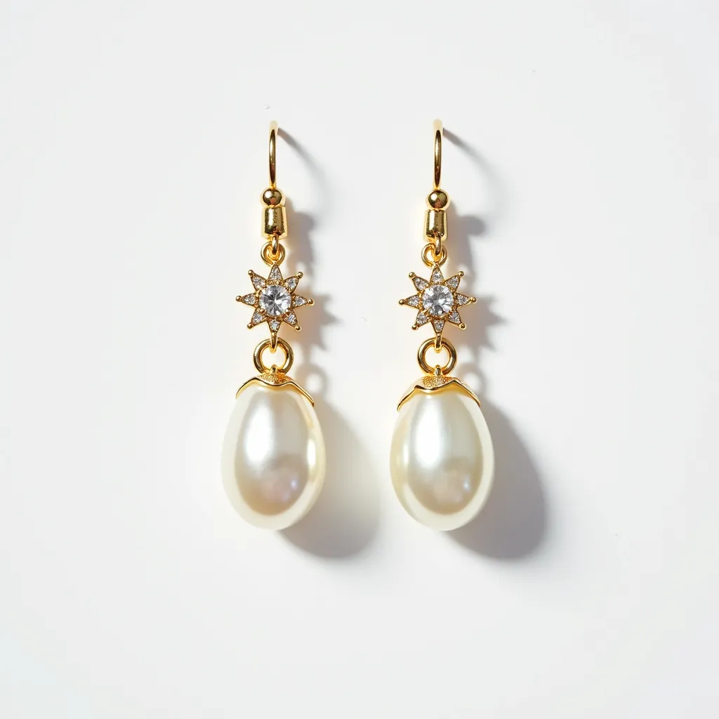 These hanging earrings feature an elegant design composed of lustrous white pearl drops, which are suspended from intricate star-shaped settings. The settings are adorned with small, sparkling clear stones that resemble diamonds, contributing a touch of brilliance to the design. The pearls, with their smooth, glossy finish, add a classic charm, while the stones are carefully prong-set to ensure security and enhance their sparkle. The earrings utilize gold-toned hooks as their attachment method, providing both durability and a complementary warm hue that enhances the overall aesthetic.