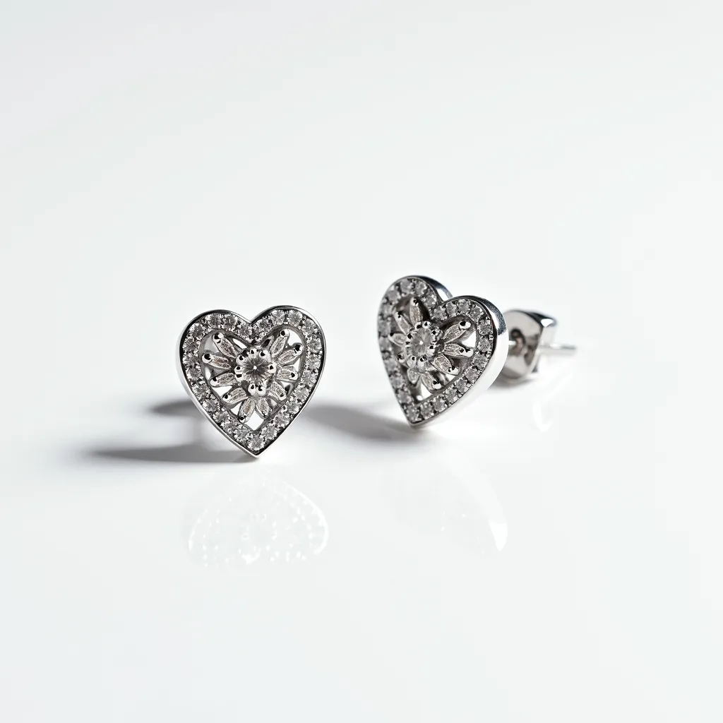 These heart diamond earrings feature a delicate design, showcasing a series of sparkling diamonds set in a heart shape. The exterior of the heart is adorned with small, round-cut diamonds forming a shimmering border. Within the heart, a detailed floral pattern adds an elegant touch, crafted from what appears to be a white metal, likely white gold or platinum, enhancing the overall brilliance of the piece. The earrings are equipped with a classic stud post and butterfly back clasp, ensuring a secure fit when worn. The combination of intricate metalwork and radiant diamonds creates a striking pair of earrings suitable for any elegant occasion.