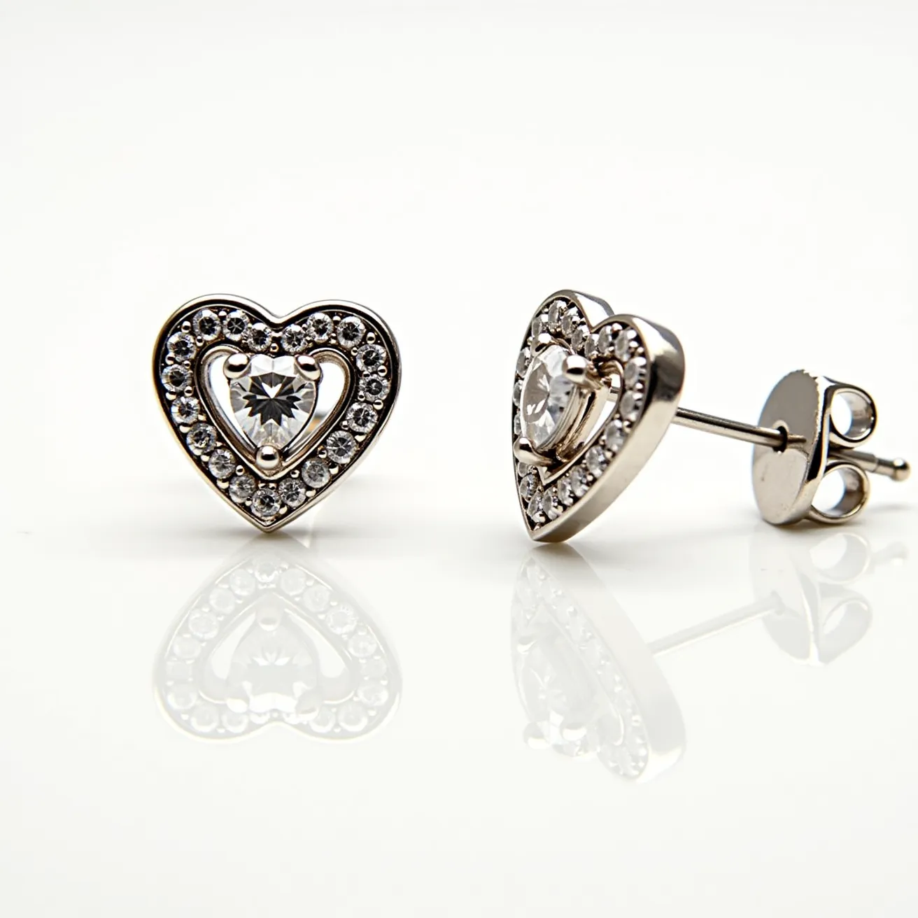 These heart diamond earrings feature a stunning design with a central heart-shaped diamond, prominently showcased with a brilliant cut to enhance its sparkle. Surrounding the central stone is a halo of smaller round-cut diamonds, each meticulously set in a secure prong setting to create a dazzling, cohesive look. The earrings are crafted from a high-quality metal, likely white gold or platinum, providing a polished and elegant finish that complements the shimmer of the diamonds. These earrings are designed with a push-back clasp, ensuring a secure and comfortable fit for the wearer. The combination of the heart motif with the luminous gemstones creates a timeless and romantic accessory.