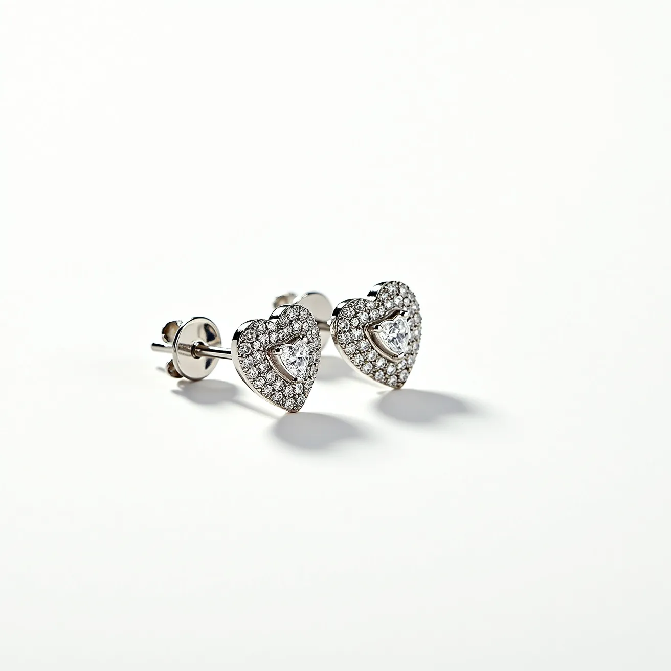 These heart diamond earrings feature a central heart-shaped diamond prominently positioned in each piece, surrounded by a pavé setting of smaller round diamonds that add extra sparkle and elegance. The diamonds appear to be set in a metal likely to be white gold or platinum, enhancing their brilliance. The earrings are secured with a butterfly clasp, providing a secure and comfortable fit. The heart-shaped design, along with the meticulous arrangement of the stones, creates a romantic and sophisticated aesthetic.