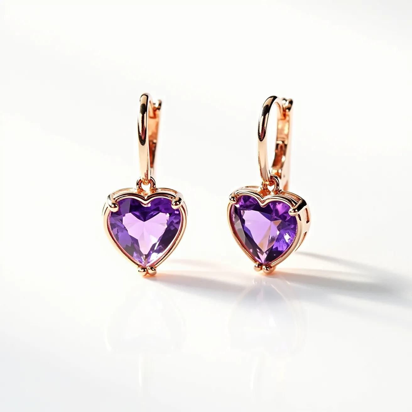 These heart earrings feature a stunning design with heart-shaped purple gemstones, likely amethysts, set in a prong setting. The cut of the gemstones showcases multiple facets, enhancing their sparkle and vibrancy. The earrings are crafted with a polished metal, probably rose gold, which complements the purple hue of the stones. They are equipped with a hinged hoop clasp, allowing for secure attachment and ease of use. The overall design balances elegance and modern appeal, making them a captivating accessory.