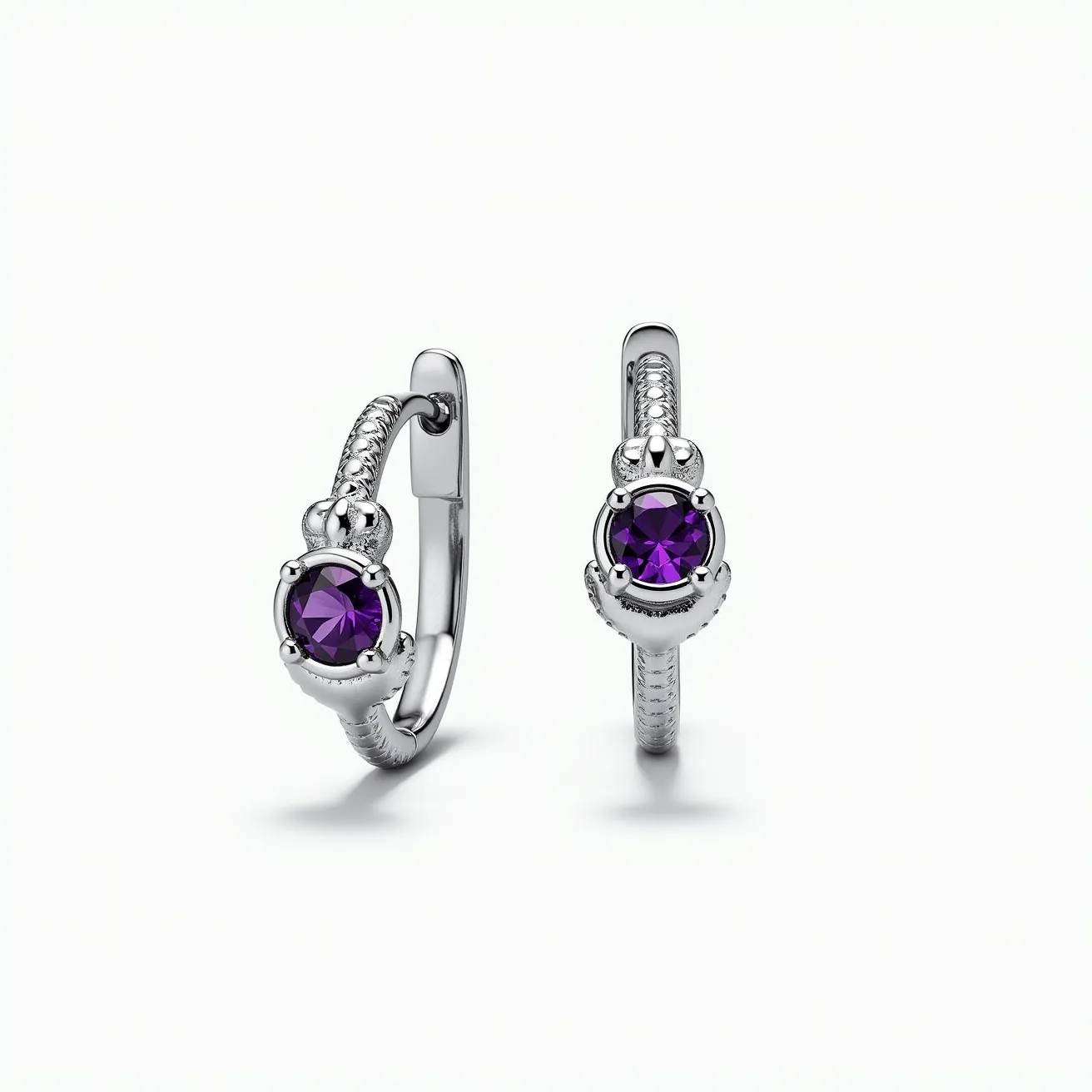 These hoop earrings are crafted from a shiny metal, likely silver, featuring a decorative band with intricate detailing that adds texture and elegance. At the center of each hoop is a striking, round-cut purple gemstone, possibly amethyst, held securely in a prong setting adorned with a crown-like design. The earrings have a hinge and post clasp mechanism, ensuring a secure and comfortable fit when worn. The combination of the metal's sheen and the gemstone's vibrant color creates a captivating contrast, highlighting the elegance of the design.