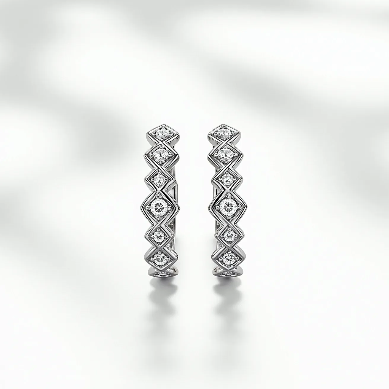 These huggie earrings showcase a sleek design crafted from a lustrous metal, likely white gold or platinum. Each earring features a series of diamond-shaped settings, each housing a brilliant-cut diamond, which adds a touch of sparkle and elegance. The stones are securely set in a channel setting, allowing the diamonds to be highlighted prominently while maintaining a smooth exterior. The earrings are designed with a hinge clasp mechanism, ensuring a snug and secure fit for the wearer. The combination of precious metal and dazzling stones creates a sophisticated and timeless aesthetic.