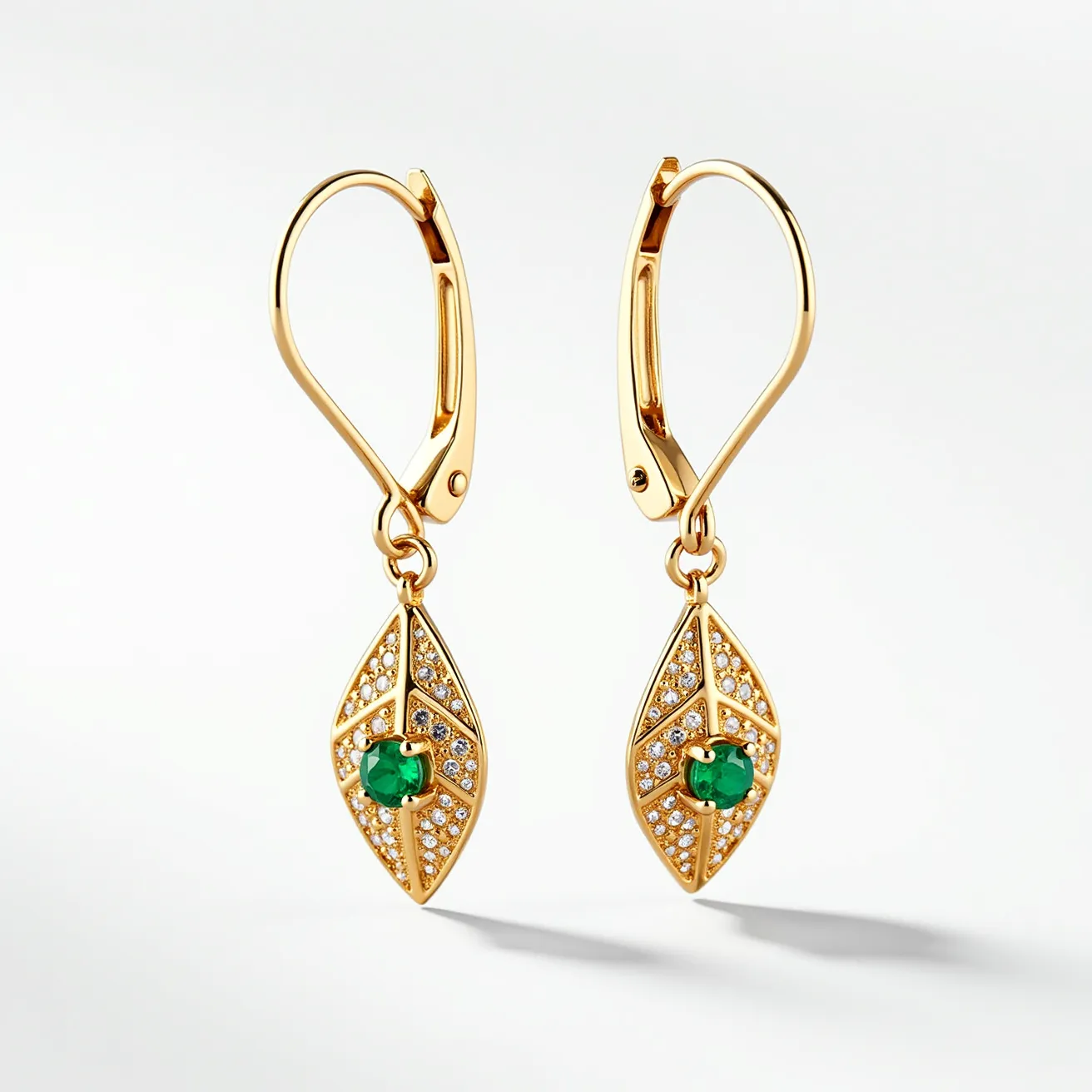 These leaf earrings are crafted from a shiny gold metal, with a design that beautifully mimics the shape of a leaf. The central feature of each earring is a vibrant green stone, likely an emerald or a similar gemstone, round in cut and prong-set to enhance its prominence. Surrounding the central stone are smaller clear stones, possibly diamonds or cubic zirconia, which are pave-set to add a sparkling effect that contrasts well with the gold metal. The earrings are equipped with secure lever-back clasps, ensuring they stay comfortably in place when worn. The overall design merges organic and luxurious elements to create an eye-catching piece.