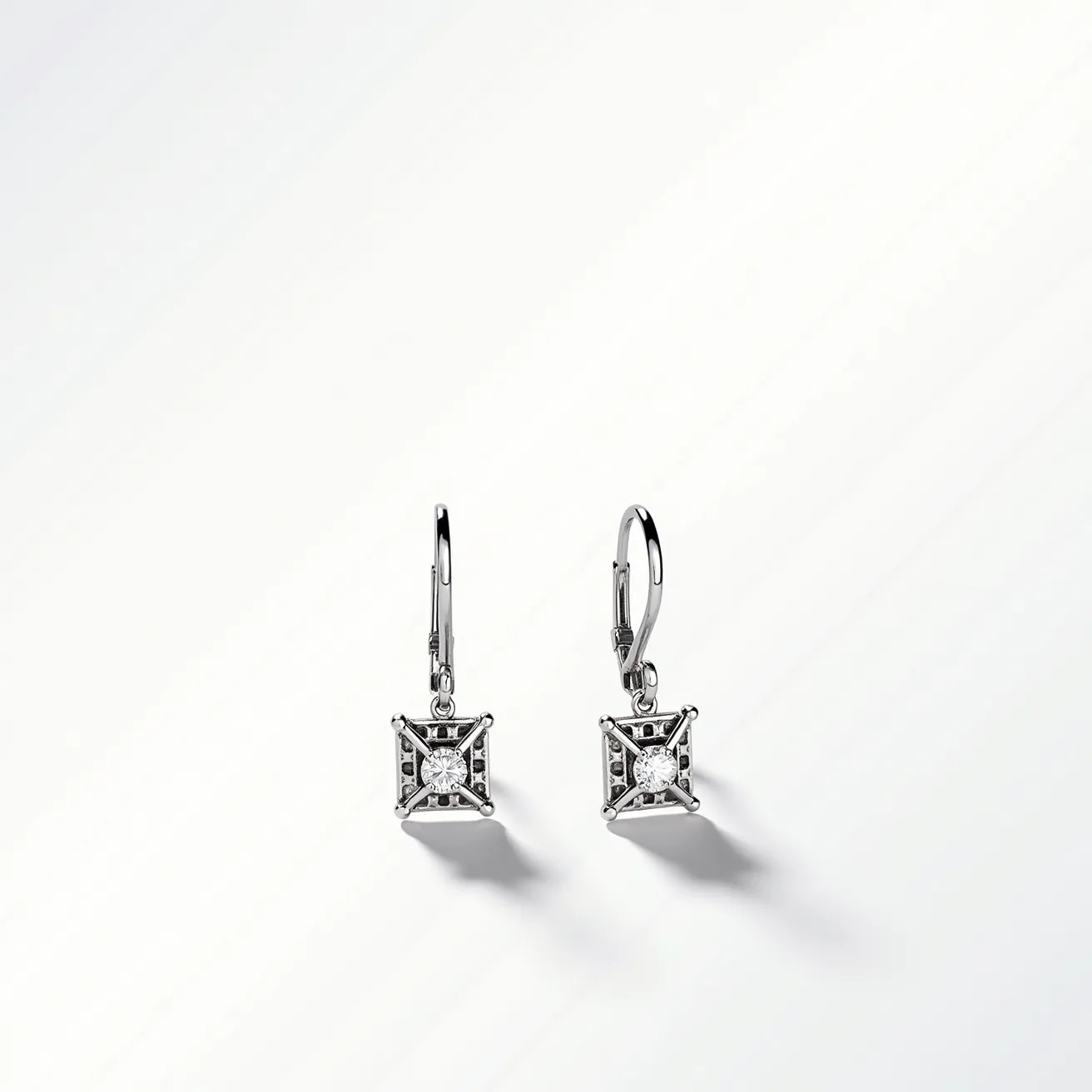 These leverback earrings feature a sleek and polished metal frame, likely crafted from silver or white gold, enhancing their elegant appearance. The focal point of each earring is a square-cut gem, resembling a diamond, securely set in a four-prong setting that ensures stability and showcases the stone's brilliance. The leverback clasp provides a secure and comfortable attachment, combining functionality with a touch of sophistication in the overall design.