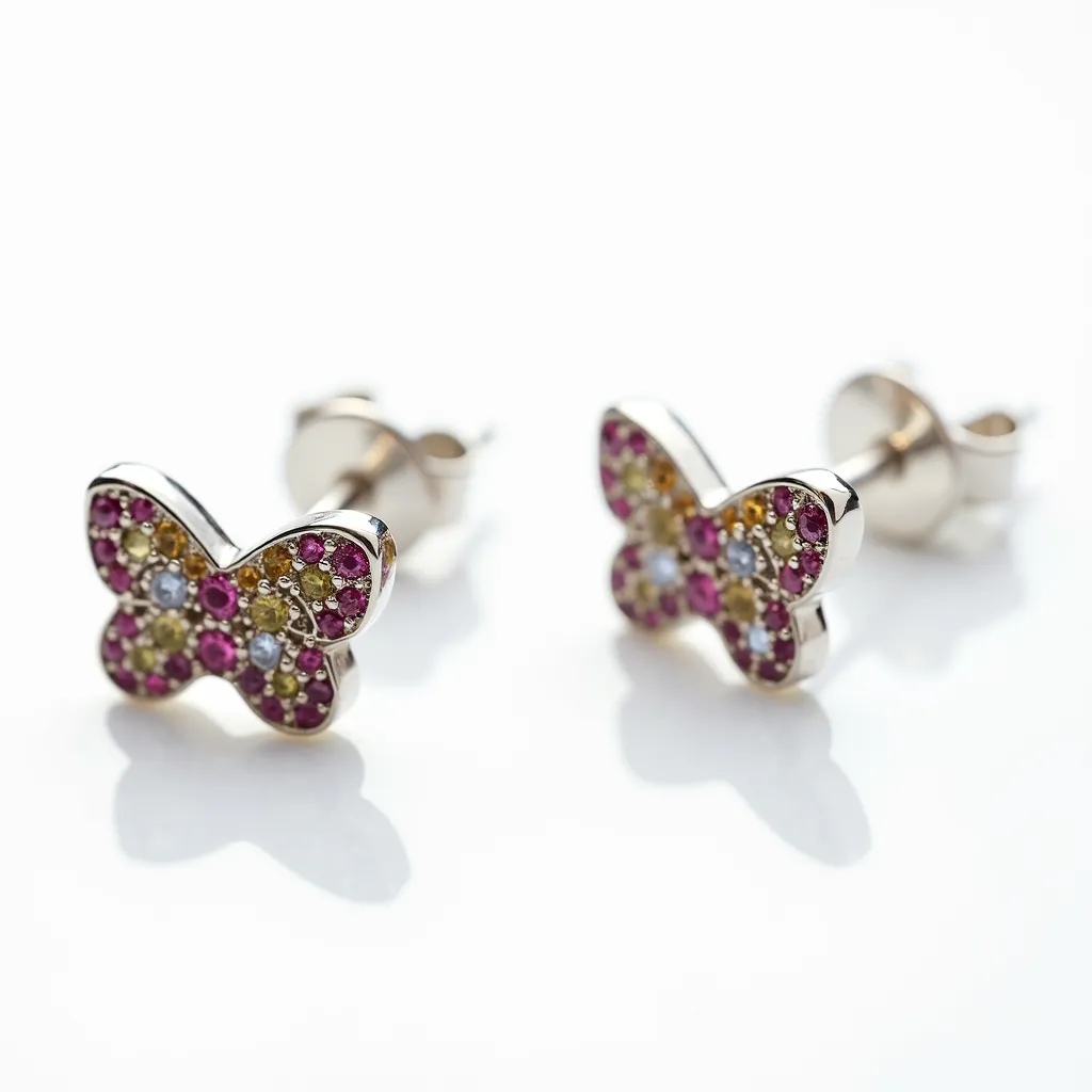 These little girl’s earrings are crafted in the shape of butterflies and set with an array of colorful stones. The design features small pink, yellow, and clear gemstones that are meticulously placed to create a vibrant mosaic effect. Each stone is uniformly round, possibly indicating a traditional round cut, contributing to a sparkling appearance. The metal setting appears to be a polished silver-tone, providing a sleek and shiny frame for the bright stones. These earrings use a post-back clasp, which ensures a secure attachment while being easy to wear and comfortable for everyday use.