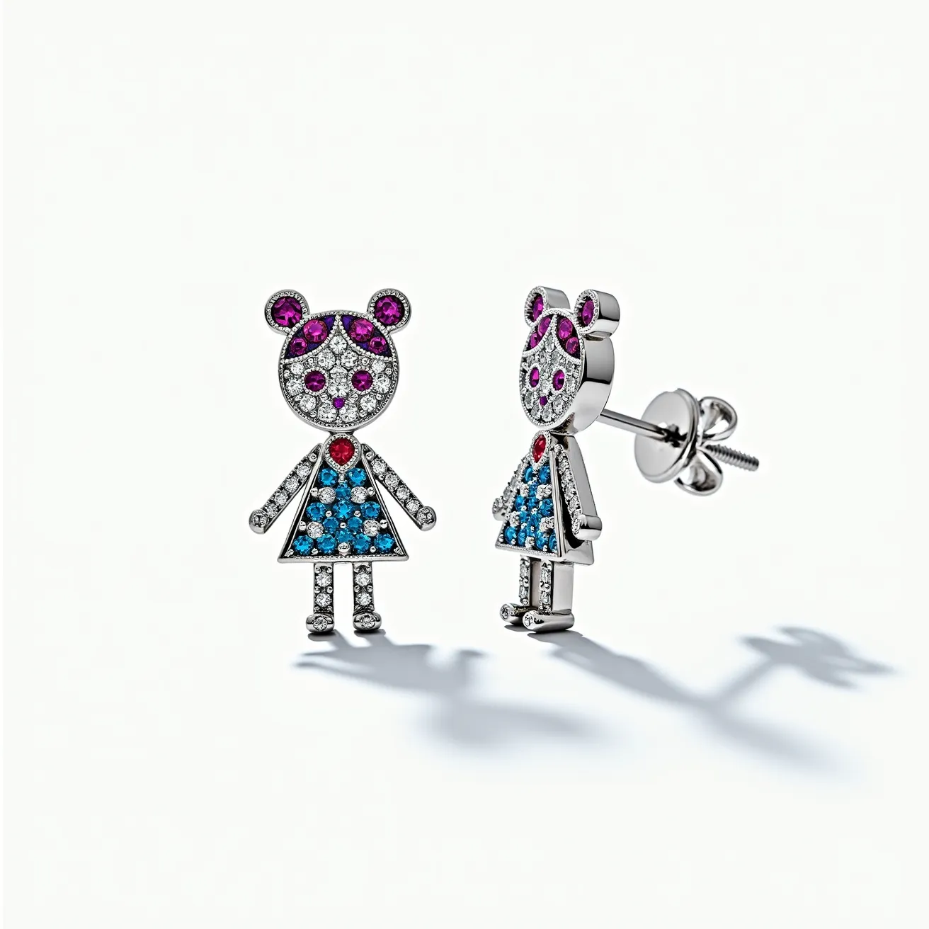 These little girl earrings feature a charming design crafted from a shiny metal base, likely silver or white gold. The earrings are shaped like a girl with detailed embellishments using sparkling gems. The face and limbs are studded with small, clear stones, possibly diamonds or cubic zirconia, set in a pave style. The hair and eyes are accentuated with purple stones, whereas the dress is highlighted with blue stones. The heart-shaped stone at the chest adds a pop of vibrant red. They are secured with a classic post and butterfly clasp, ensuring both style and comfort for the wearer.