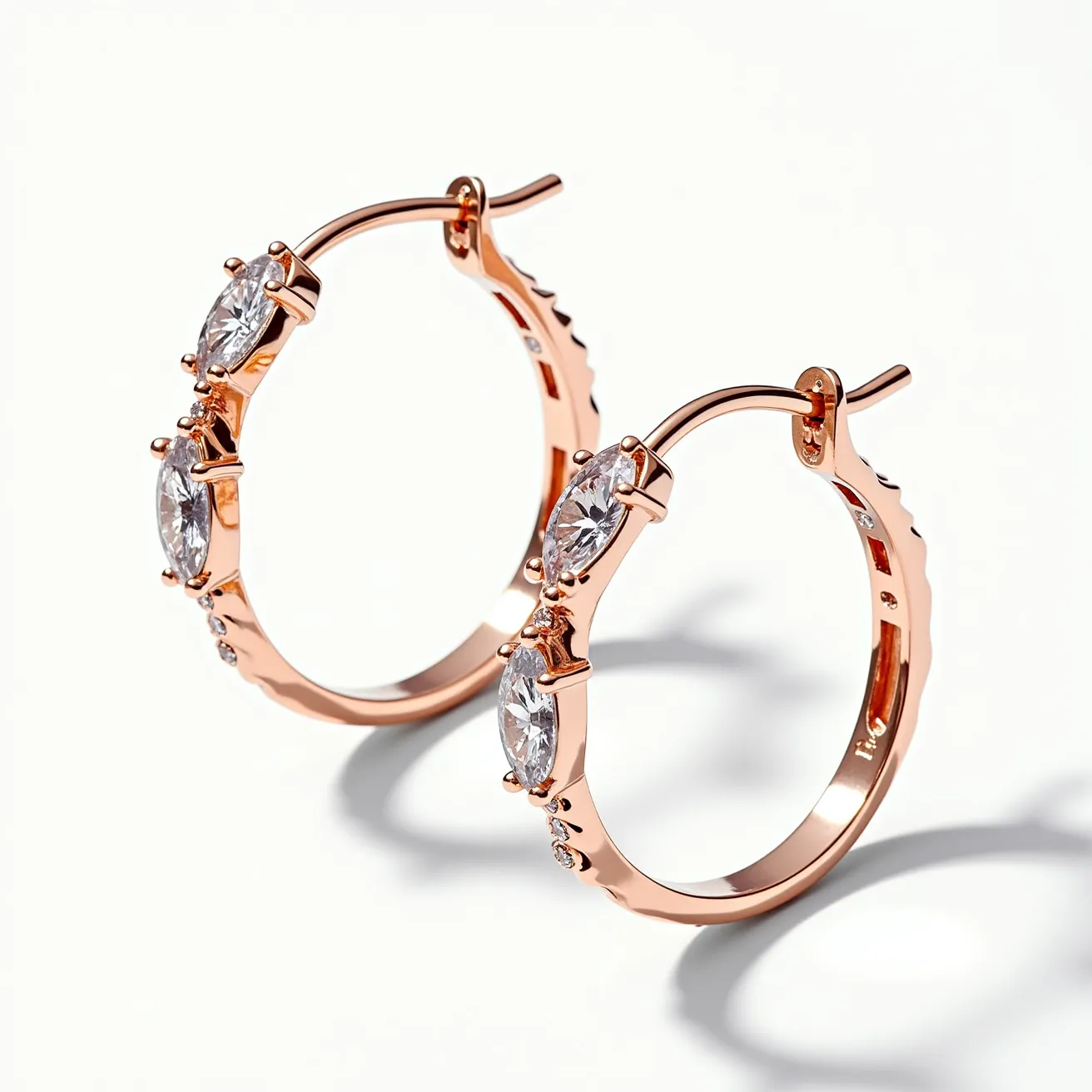 These loop earrings feature a sleek and elegant design crafted from rose gold, providing a warm and luxurious appearance. The earrings are adorned with marquise-cut gemstones, set in prong settings, which add a touch of sparkle and sophistication. The stones are strategically positioned along the loops to enhance their brilliance and catch the light beautifully. The earrings display a secure latch-back clasp, ensuring both ease of wear and stability. The combination of the rose gold base with the shimmering gemstones creates a timeless piece suitable for various occasions.