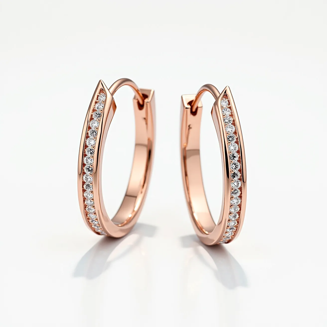 These loop earrings are crafted from a polished rose gold metal, exuding a warm and elegant hue. The surface of each hoop is lined with a series of small, round-cut diamonds, meticulously set in a pavé style that enhances their sparkle and brilliance. These stones are securely embedded into the front outer part of the earrings, adding a luxurious touch without overwhelming the design. The earrings seem to feature a hinge clasp, which ensures secure closure while maintaining a seamless and fluid aesthetic. The combination of the rose gold metal and the dazzling diamonds creates a refined and classic style, perfect for both everyday wear and special occasions.