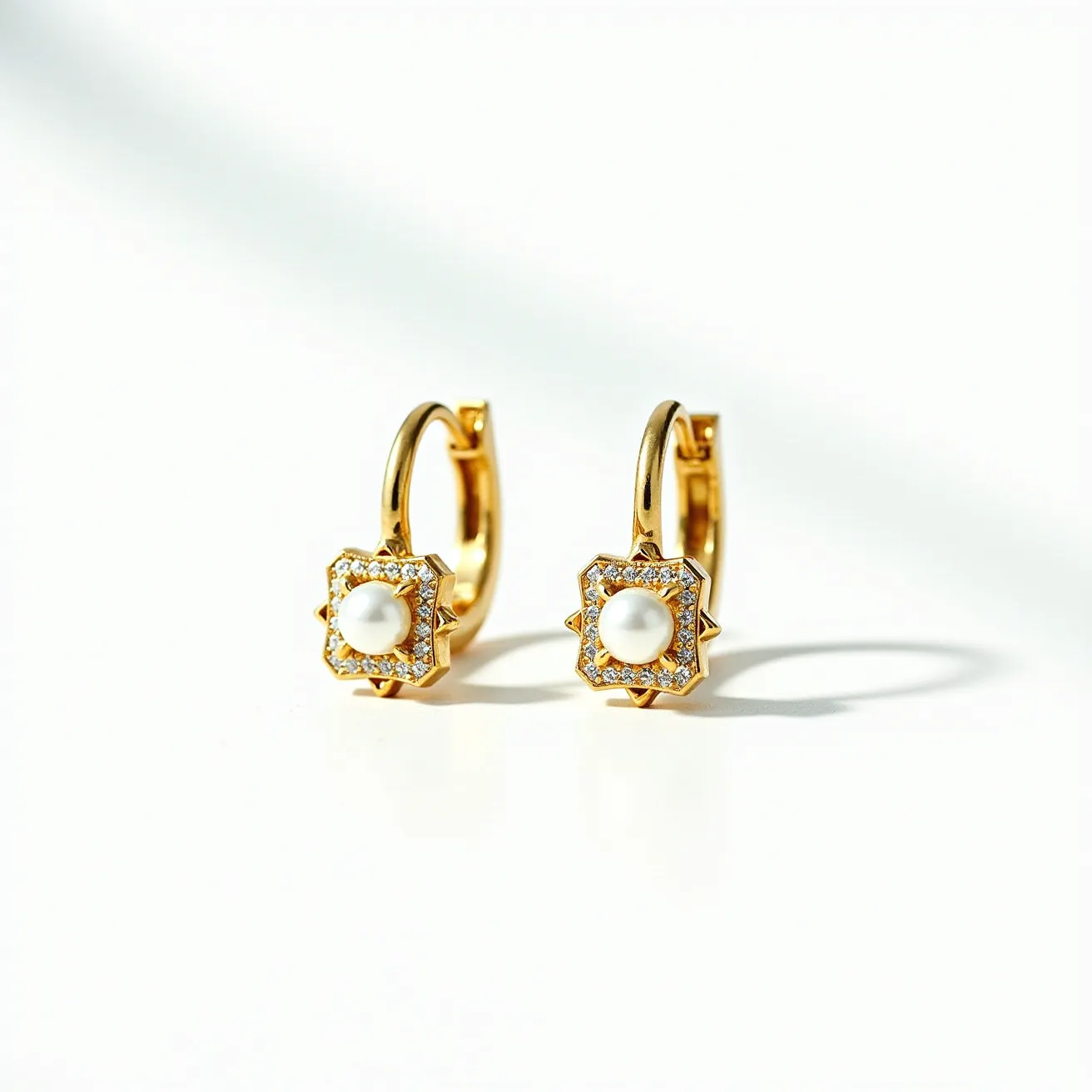 These love earrings feature a sophisticated design with a prominent pearl at the center, set in a star-shaped gold setting. The pearls are surrounded by small, clear gemstones, possibly diamonds or cubic zirconia, arranged in a pavé style to enhance their brilliance. The earrings are crafted from gold, providing a classic and luxurious appearance. Each earring is designed as a hoop, suggesting a hinged hoop clasp or similar mechanism for attachment, offering both security and style.