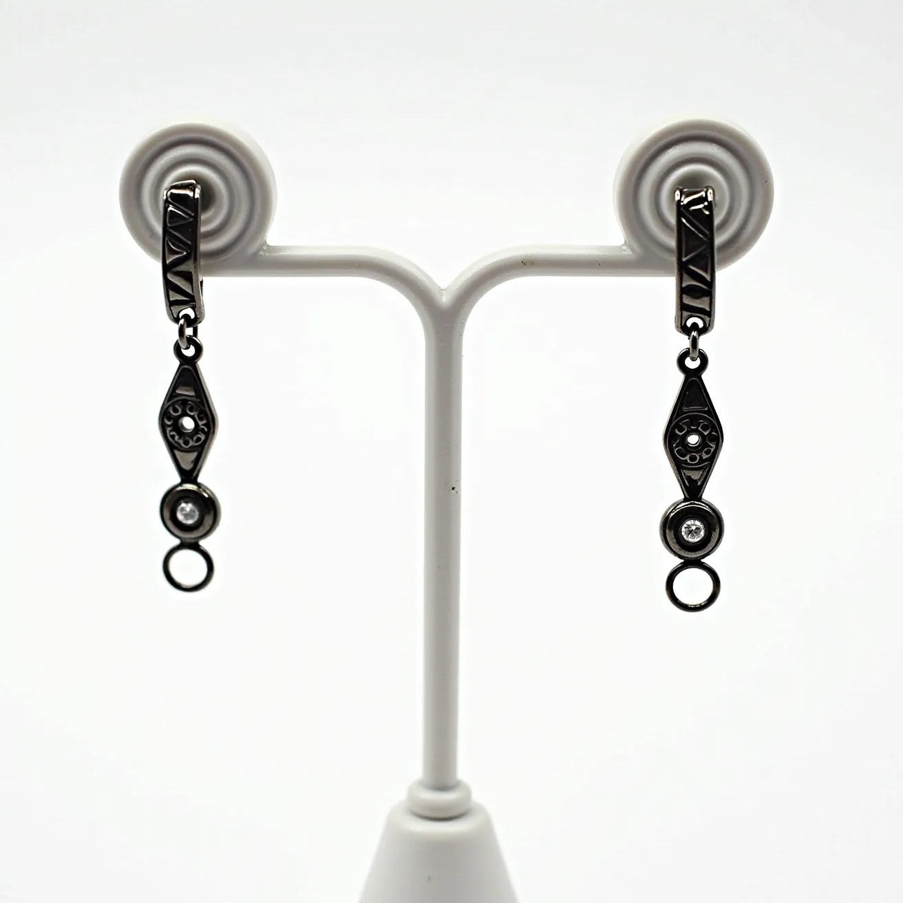 These mens dangle earrings showcase a metal material with a dark finish, featuring geometric design elements on the upper part of the dangle. They include a circular gem, likely a clear stone such as a diamond or cubic zirconia, set in a bezel setting, which adds a touch of elegance to the design. The earrings employ a classic post and hinge clasp for a secure attachment, allowing them to dangle freely while being worn. The design is both modern and sophisticated, making it suitable for various occasions.