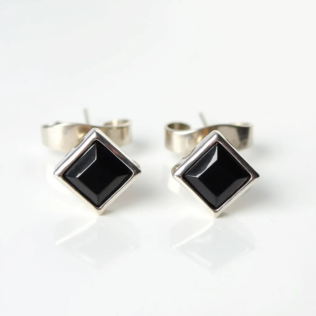 These men's earrings feature a sleek, modern design with square black stones set in a silver-toned metal framework. The stones are cut with a flat surface and beveled edges, providing a polished and sophisticated appearance. The setting highlights the dark stones with a subtle silver border that enhances the overall contrast. These earrings use a post and butterfly clasp attachment, ensuring a secure fit when worn.