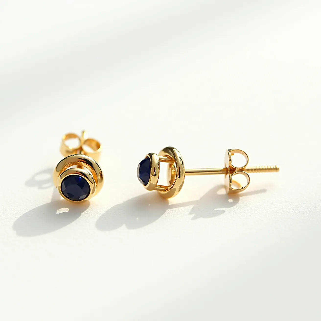 These men's earrings feature a stunning deep blue gemstone, likely a sapphire, with a faceted round cut that enhances its brilliance. The stone is securely set in a polished gold setting, providing a classic and elegant contrast. The earrings utilize a screw-back clasp for secure attachment, ensuring they stay comfortably in place during wear. The overall design combines luxury with sophistication, making them suitable for various occasions.