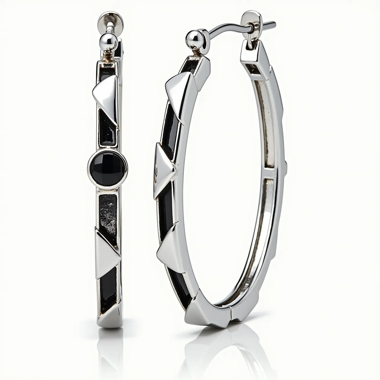 These men's hoop earrings feature a sleek and modern design crafted from a shiny silver-toned metal. The hoops are adorned with black geometric accents, including a round black stone set in a bezel, adding a touch of elegance and contrast. The earrings have a post and latch back closure, providing a secure fit while maintaining the overall streamlined appearance. The triangular and rectangular patterns along the hoop create a bold visual texture, enhancing the contemporary style of these earrings.