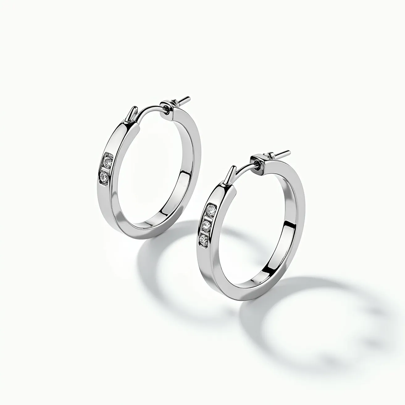 These men's hoop earring pair is crafted from a polished metal with a sleek and modern appearance. Each earring features three small, round-cut stones set in a channel setting, adding a touch of sparkle to the design. The hoops are equipped with a hinge clasp mechanism for secure and easy attachment, ensuring they stay in place comfortably. The overall style combines simplicity and elegance, making them a versatile accessory for various occasions.