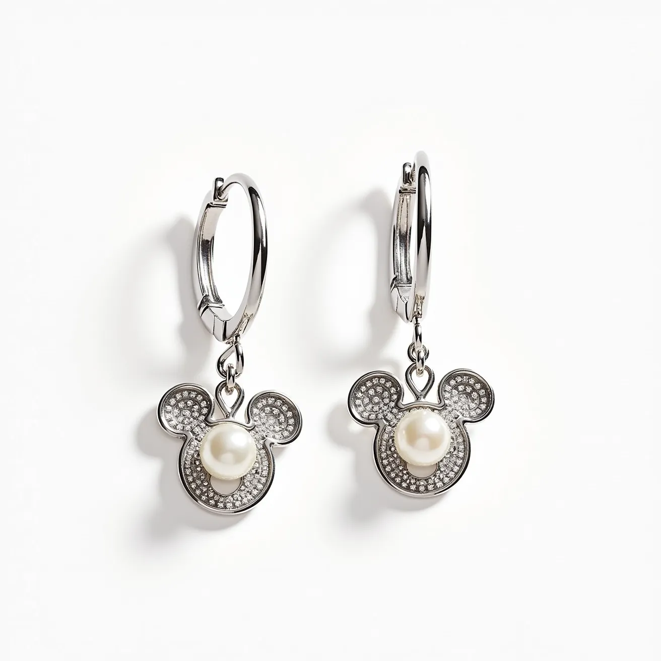 These Mickey Mouse earrings feature a playful design that incorporates a pearl-like gem set prominently at the center of the iconic silhouette. The outline is adorned with numerous small, round-cut crystals, adding a sparkling effect to the piece. The earrings are likely made of a polished metal, possibly silver or stainless steel, providing a sleek and shiny appearance. They are attached to hoop bases with a hinge clasp, ensuring a secure fit while allowing for easy wear and removal. The combination of materials and design elements creates a whimsical yet elegant accessory, perfect for fans of the beloved character.