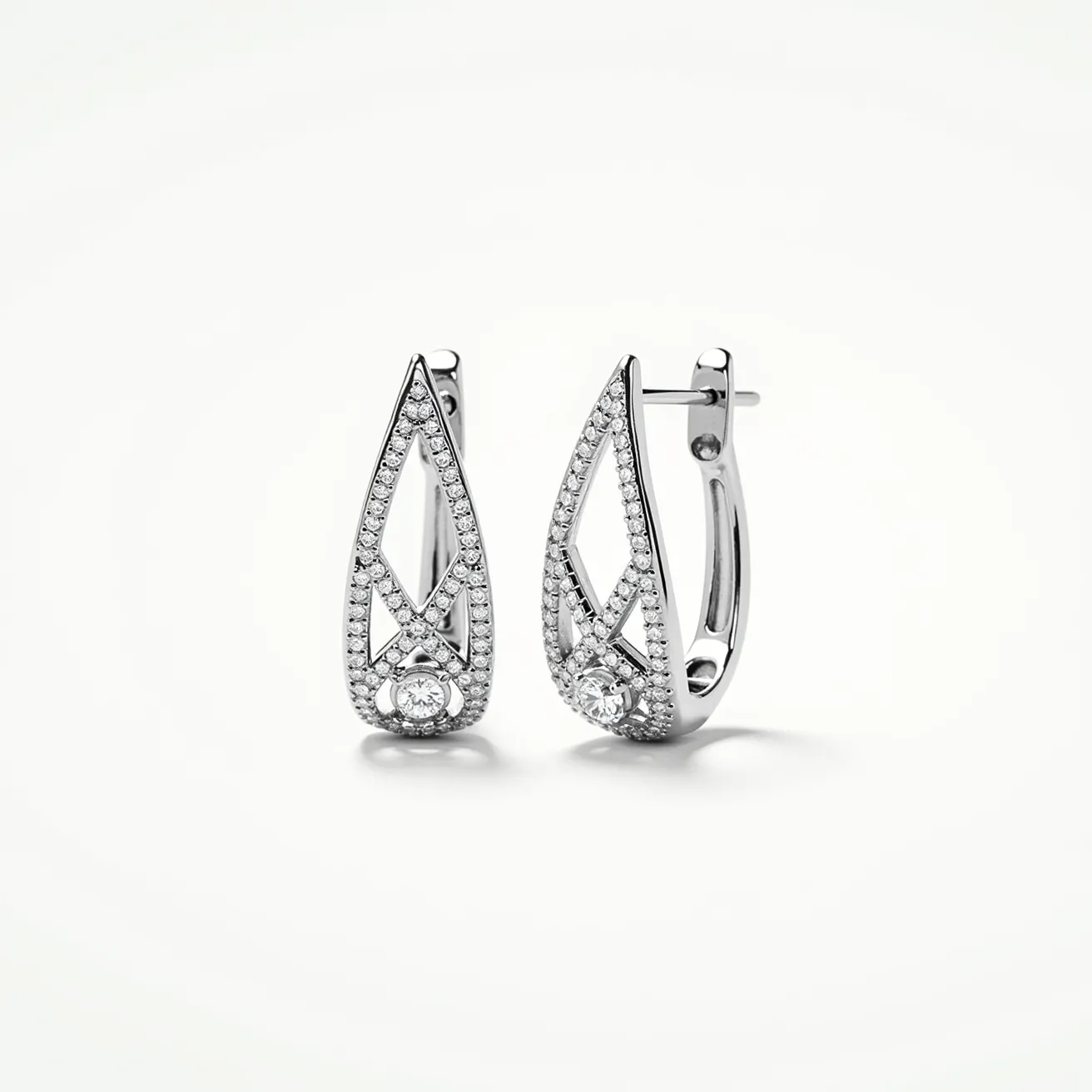 These moissanite earrings feature an elegant drop design adorned with small moissanite stones, arranged in a pave setting that lines the intricate metal work. The primary metal appears to be a polished, bright silver-tone, likely sterling silver or white gold, enhancing the sparkle of the moissanites. Each earring showcases a prominent round moissanite stone at the bottom of the teardrop shape, skillfully set to catch light from every angle. The attachment mechanism includes a hinged back clasp, providing secure wear and ease of use.