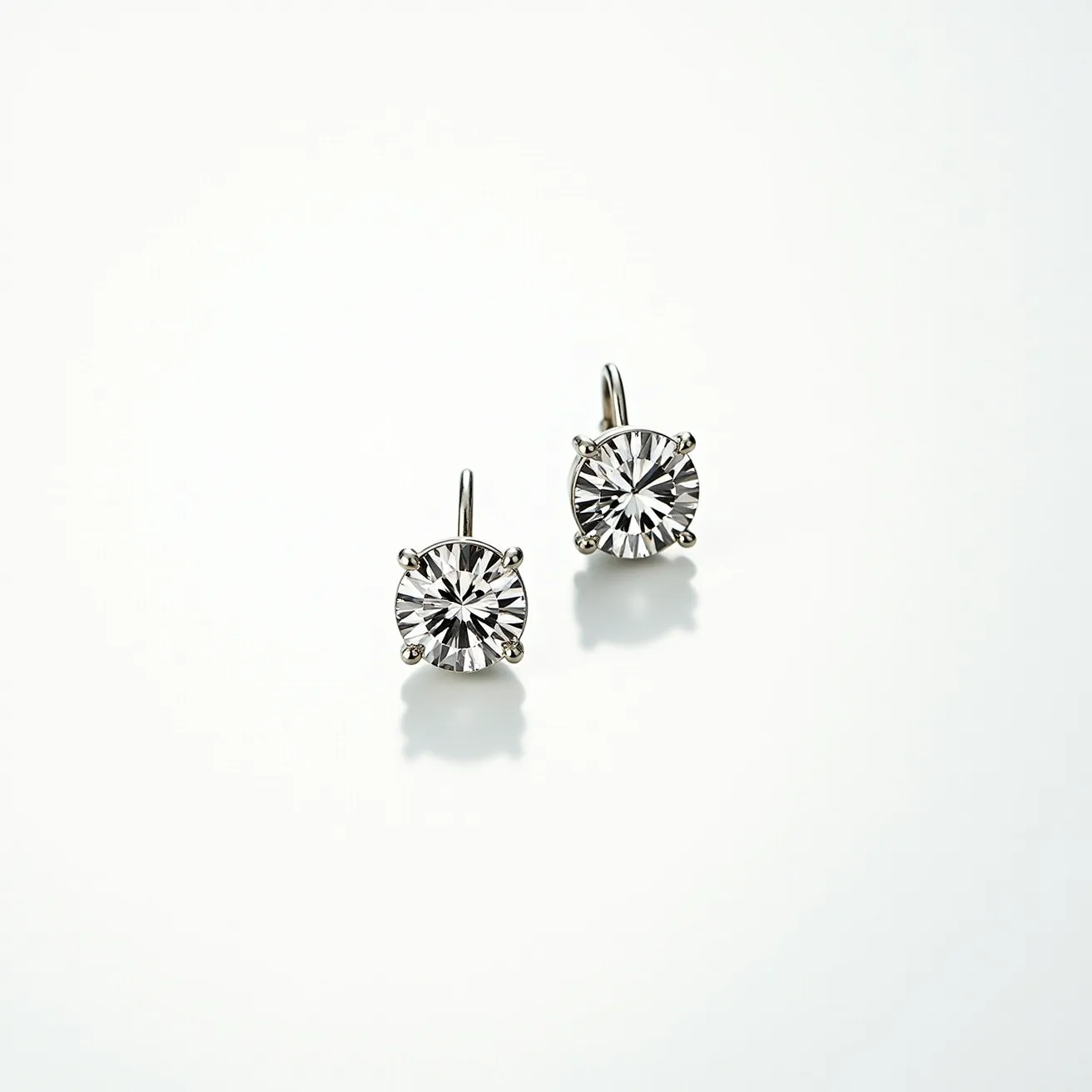 These moissanite earrings feature a pair of brilliant-cut stones, skillfully set in a classic four-prong setting that showcases their dazzling radiance. The stones are round in shape, enhancing their brilliance, and are likely crafted from moissanite, known for its exceptional fire and sparkle. The metal used for the setting and hooks appears to be a polished silver or white gold, complementing the clarity and brightness of the gems. The earrings are designed with a leverback clasp, providing both security and a comfortable fit when worn.