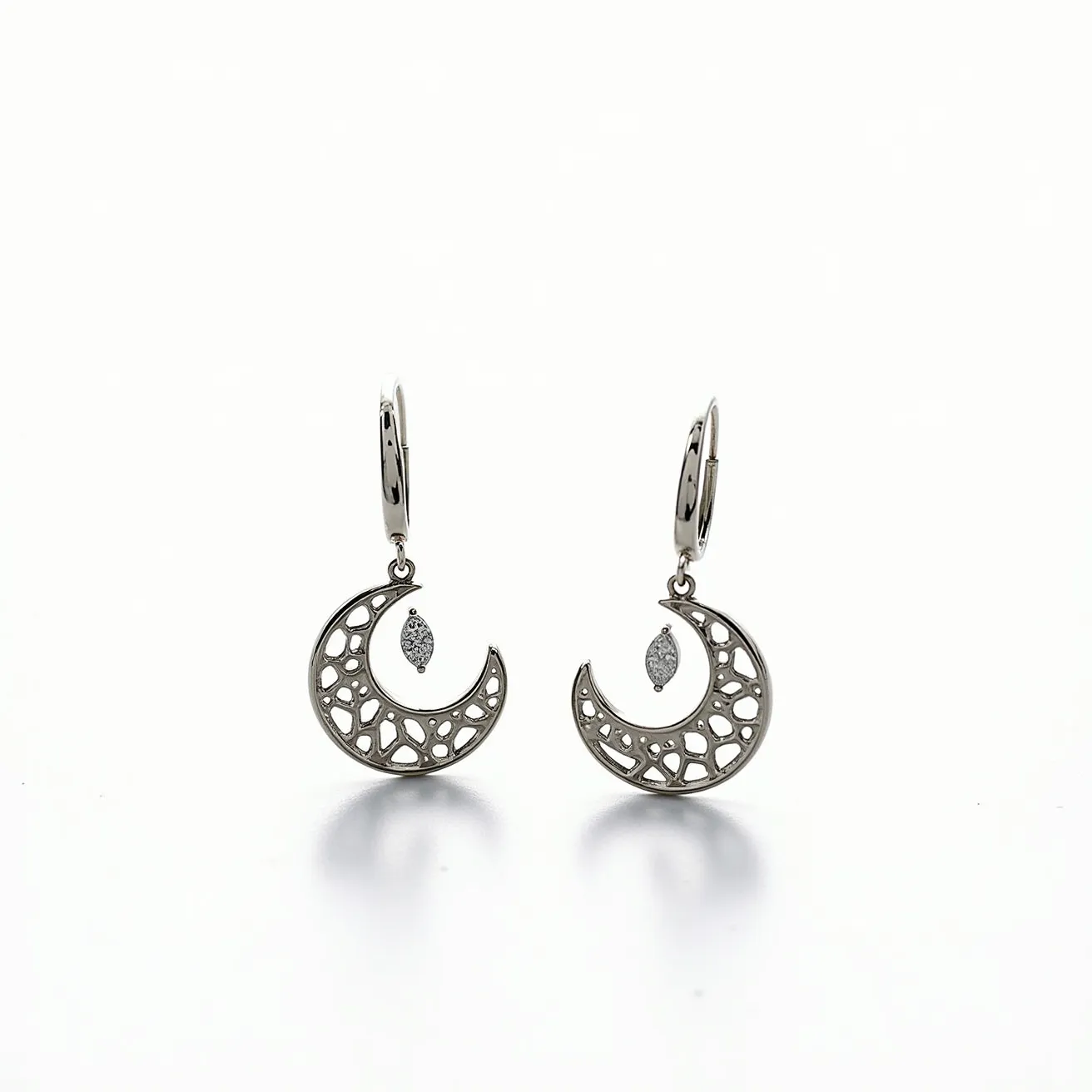 These moon earrings feature a crescent moon design intricately crafted from a lustrous metal, likely silver or white gold, giving them a polished and elegant appearance. The metal is shaped into a perforated pattern, enhancing the design with a delicate, airy look. Suspended within each crescent is a single marquise-cut gem, possibly a diamond or a similar clear stone, set in a minimalist prong setting that adds a touch of sparkle and contrast to the earrings. The earrings are attached with lever-back clasps, which provide a secure and comfortable closure.