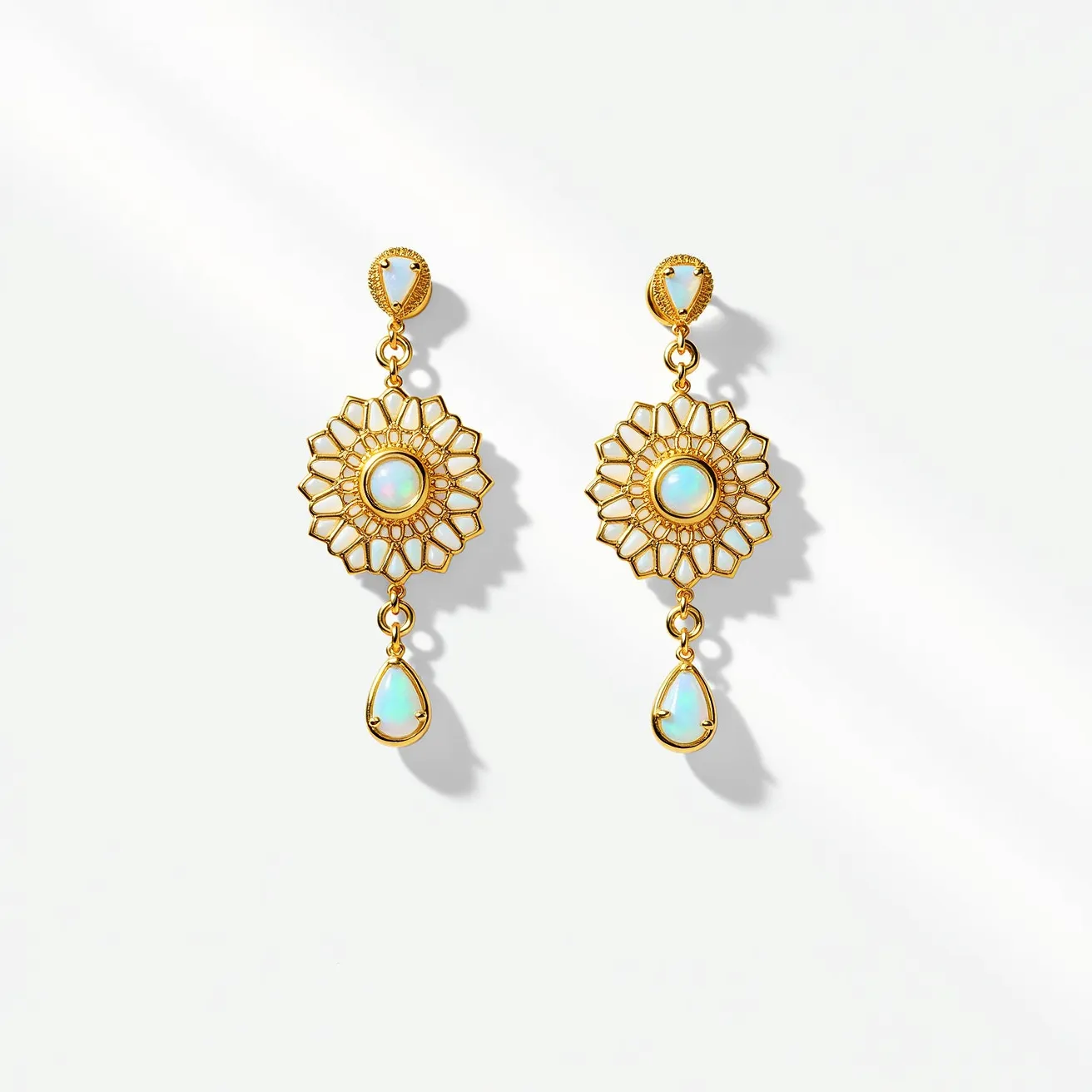 These opal earrings feature a stunning design with a prominent use of gold-toned metal, creating a floral and geometric motif. At the center of each earring is a round opal, set in a bezel that highlights its luminescent qualities. The design radiates outward in an intricate filigree pattern, offering a delicate and ornate appearance. Above the main opal centerpiece, there is a smaller, triangular opal set in a similar bezel, adding an elegant touch. Hanging from each main piece is a teardrop-shaped opal, also secured in a bezel setting, offering movement and a graceful finish to the design. The earrings attach to the ear with a post back, ensuring a secure and comfortable fit.