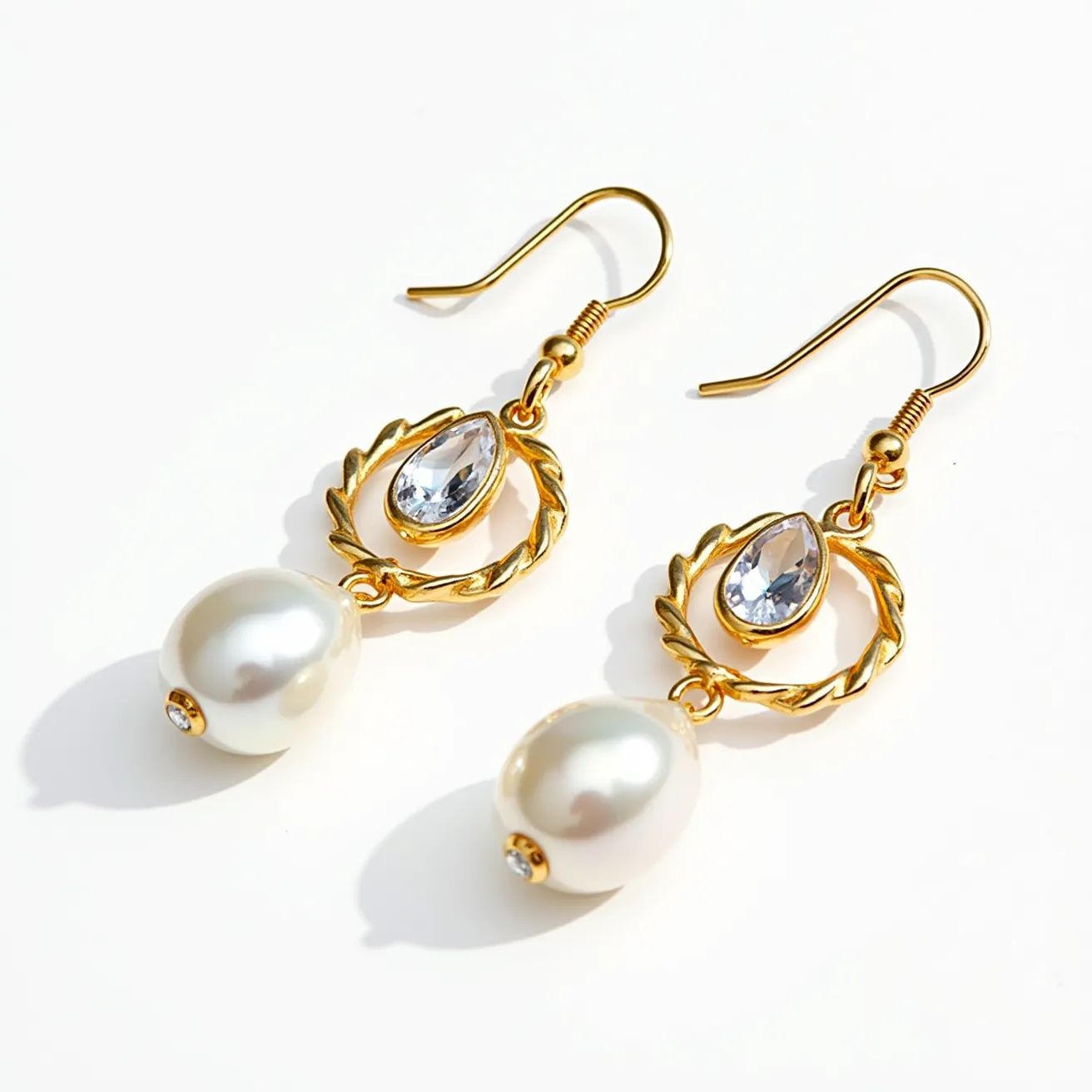 These pearl drop earring set features elegant craftsmanship with a combination of lustrous, white pearls and gold hardware. Each earring is adorned with a teardrop-shaped, clear gemstone set in a bezel setting, providing a sparkling accent above the pearl. The gold metal frame includes a decorative, twisted loop that enhances the overall design. The earrings are secured with a fishhook style clasp, allowing for comfortable wear and easy insertion. The harmonious blend of pearls, gemstones, and gold gives these earrings a timeless and sophisticated appeal, suitable for various occasions.