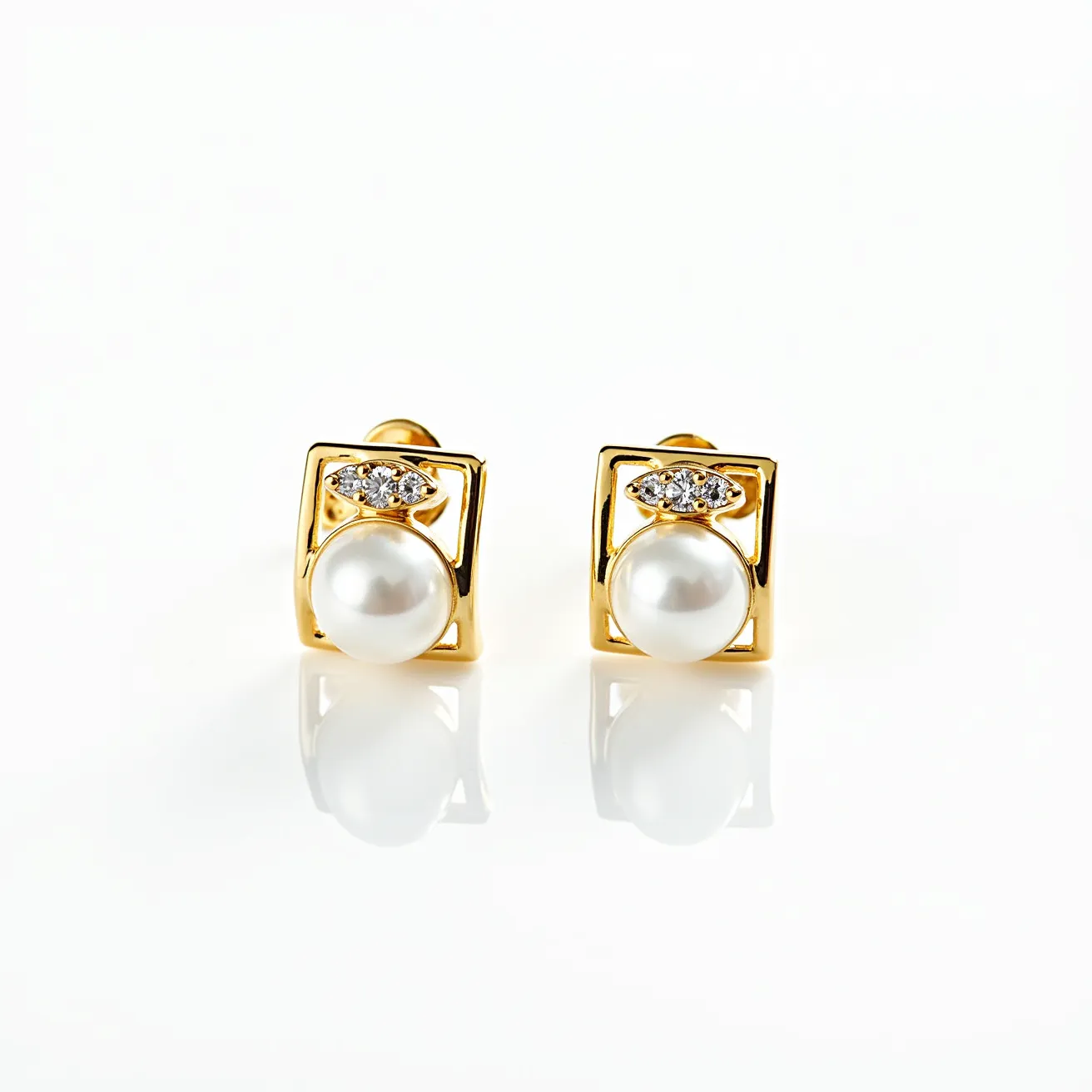 These pearl stud earrings feature prominent, lustrous pearls set within elegant gold frames. Above each pearl, a cluster of small, round-cut diamonds adds a touch of brilliance, securely set in a pavé style. The gold frames provide a classic and sophisticated backdrop, enhancing the pearls' natural sheen. The earrings are attached with a traditional post-back closure, ensuring a secure fit while maintaining the design's sleek and refined aesthetic.