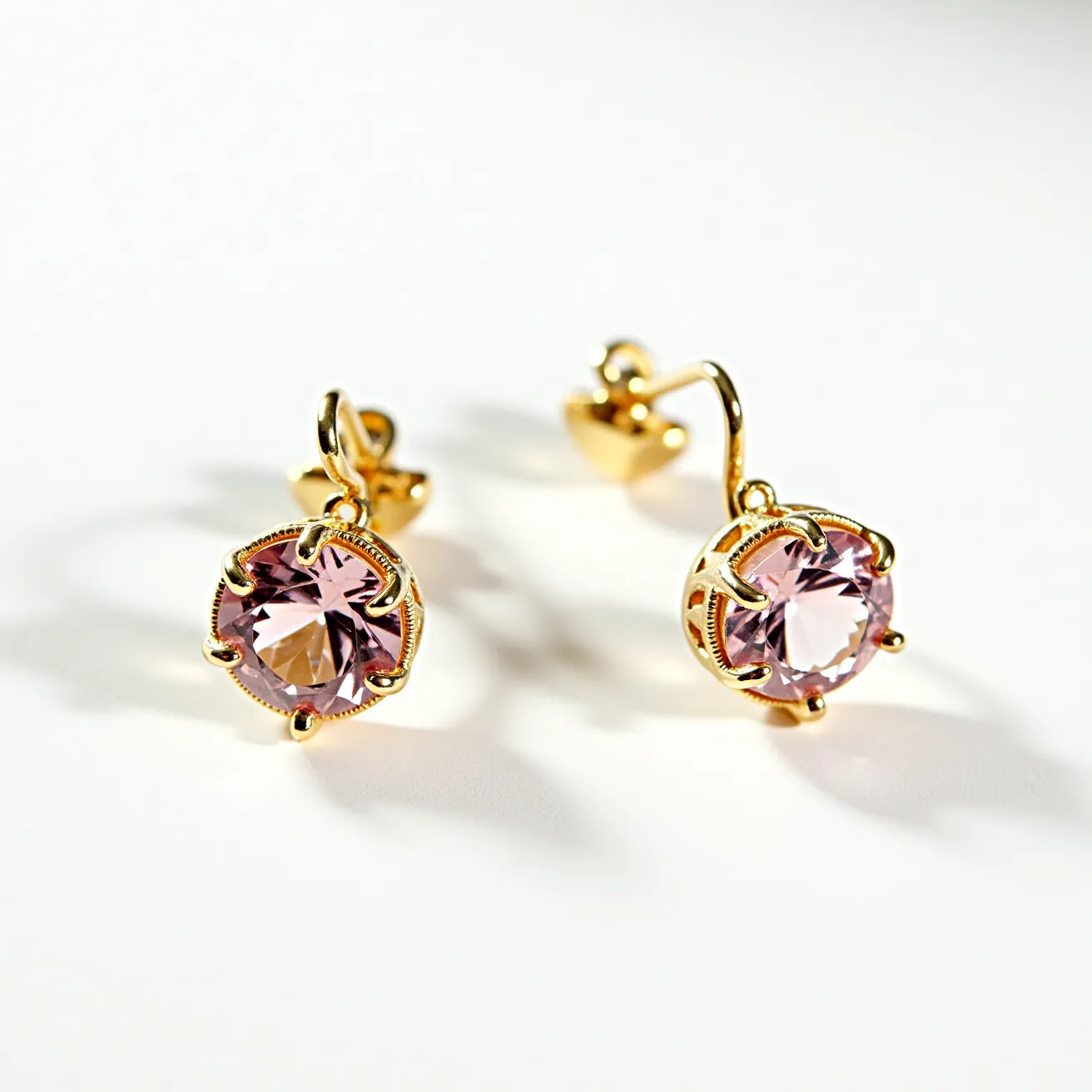 These pink earrings feature a prominent round-cut pink gemstone set in a delicate prong setting that highlights its sparkle. The stone appears to be securely held by four prongs crafted from gold or gold-tone metal, adding a touch of elegance and contrast. The earrings attach with a post and screw-back clasp, ensuring a secure fit when worn. The design combines simplicity with a classic charm, making these earrings a versatile accessory for various occasions.