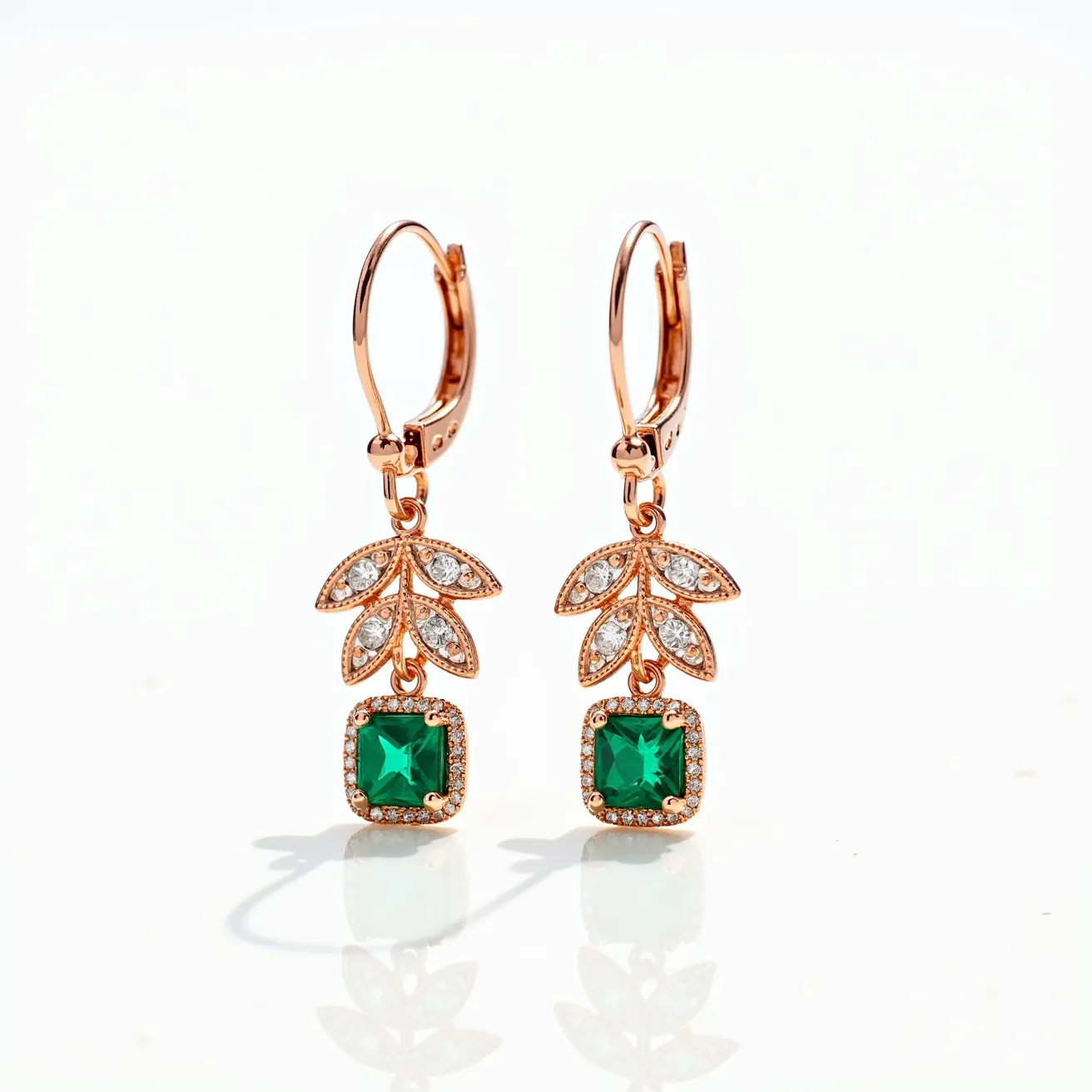 These rose gold earrings feature a lever-back clasp, providing a secure attachment. Each earring showcases an elegant leafy design with small, clear round stones set in a pave style on the leaf shapes. Dangling below the leaves is a prominent, square-cut green gemstone, framed elegantly with smaller clear stones forming a halo effect. The combination of rose gold with the vibrant green gemstone and sparkling clear stones gives these earrings a sophisticated and luxurious appeal.