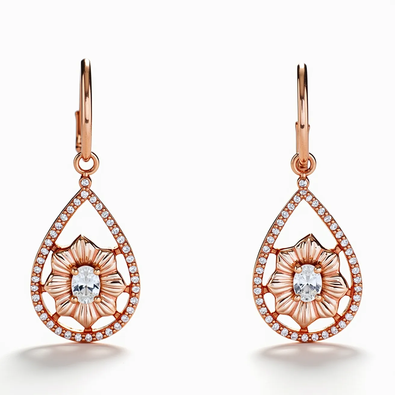 These rose gold earrings feature an exquisite teardrop design outlined with a series of small, sparkling clear stones, likely diamonds, set in a pavé style. At the center of each earring is a flower motif, highlighting a faceted oval gemstone that resembles a clear quartz or diamond, set within the petals that add a delicate, floral touch. The earrings showcase a leverback clasp attachment, ensuring secure and comfortable wear while enhancing their elegant appearance. The combination of rose gold and gemstones creates a harmonious and stylish look, perfect for sophisticated fashion.