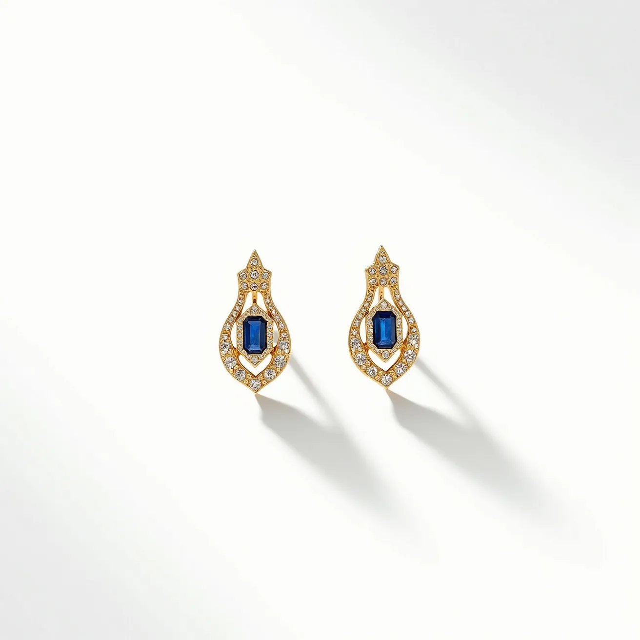 These sapphire earrings feature an exquisite design with a central sapphire gemstone, expertly cut in an emerald shape to enhance its deep blue hue. The sapphires are framed in a halo of small round diamonds, adding a sparkling brilliance to the overall appearance. These gemstones are set in a rich yellow gold material, which contrasts beautifully with the dark blue sapphires and clear diamonds. The earrings incorporate a geometric openwork design that emphasizes elegance and sophistication. Additionally, the earrings are equipped with a secure post and butterfly clutch back, ensuring a comfortable and reliable fit.