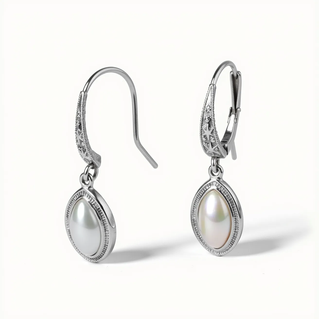 These silver earrings feature an elegant design incorporating sleek silver metal and luminous pearls as the primary stones. Each pearl is encased in a smooth, oval-shaped bezel setting that highlights its lustrous surface. The earrings are attached via a secure lever-back clasp, offering ease of wear and assurance of staying in place. Subtle detailing along the clasp connection adds a touch of sophistication, accentuating the overall graceful appearance of the jewelry.