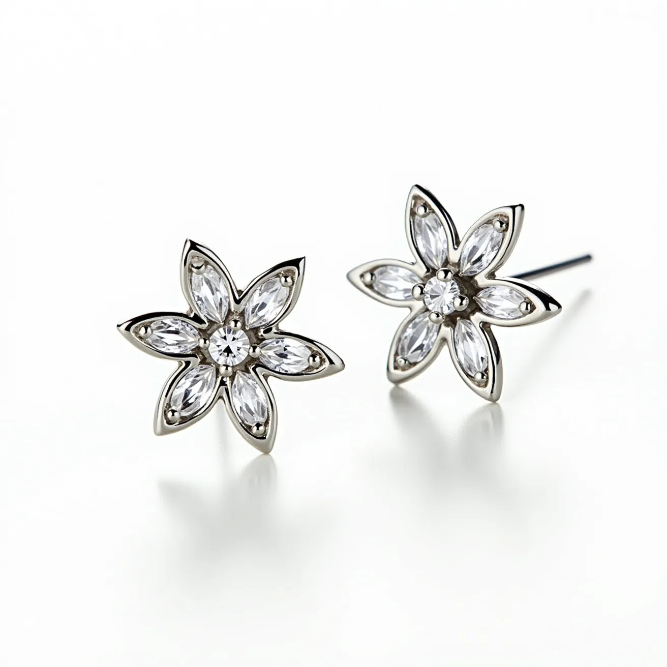 These silver earrings feature a charming floral design, crafted with a gleaming silver setting that enhances their elegant appearance. Each earring showcases a central round-cut gem, likely a diamond or a diamond simulant, surrounded by six marquise-cut stones that form the petals of the flower. The stones are meticulously set in a prong setting, allowing maximum light to enhance their brilliance and sparkle. The earrings are secured with a straight post, likely accompanied by a push-back or butterfly clasp, ensuring a secure and comfortable fit. This intricate design and quality craftsmanship make these earrings a sophisticated accessory for any occasion.