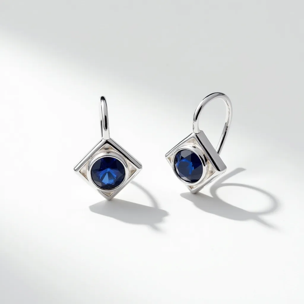 These silver earrings feature a sleek, minimalist design with a square-shaped silver setting that holds a deep blue gemstone. The gemstone appears to be round-cut, enhancing its brilliance and adding a touch of elegance to the overall appearance. The stones are securely set in a bezel setting, which not only provides a contemporary look but also ensures stability and durability. These earrings are equipped with a simple hook clasp, making them easy to wear and adding to their graceful aesthetic. The combination of silver and blue creates a striking contrast, making these earrings a standout accessory for any occasion.