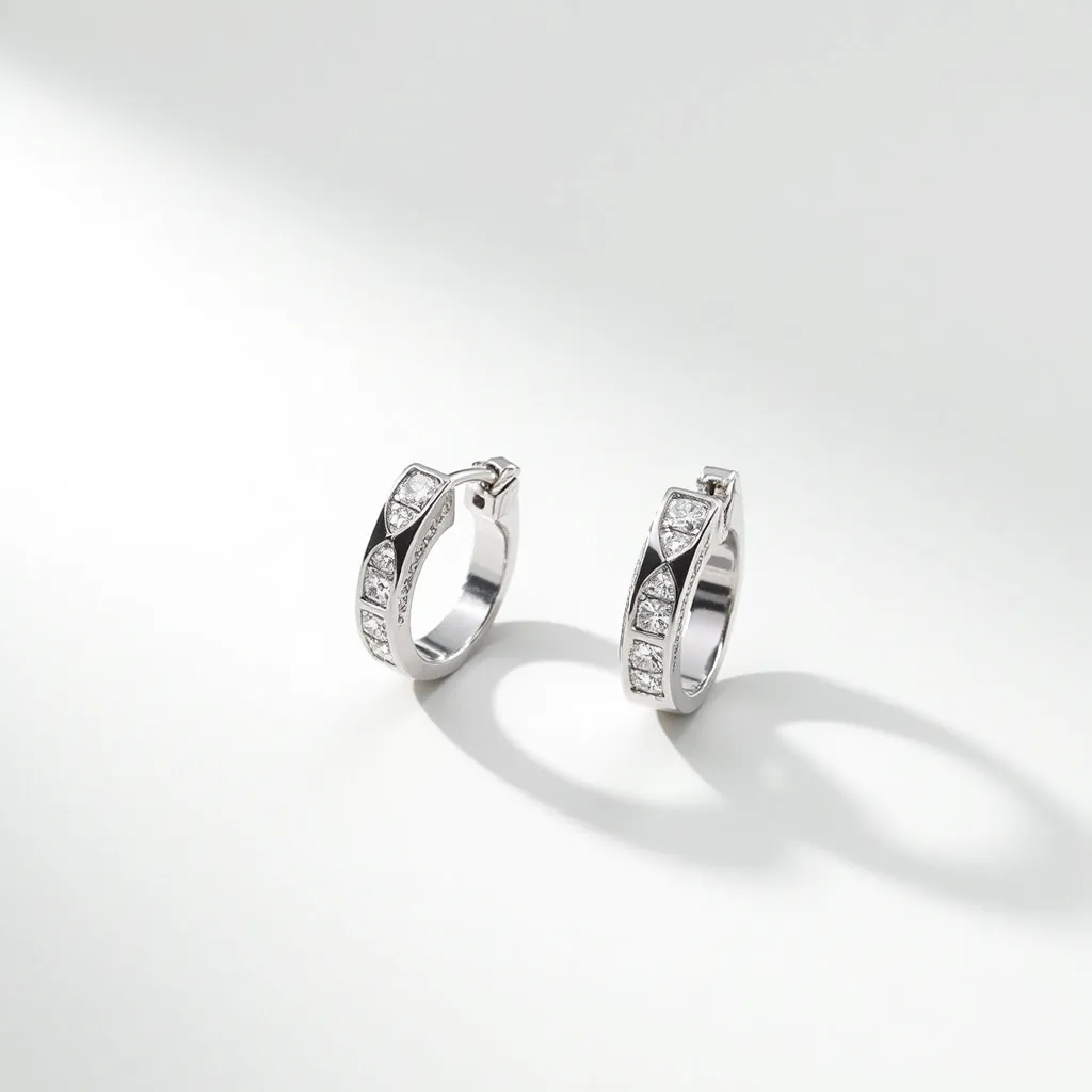 These silver hoop earrings are crafted from a shiny silver-toned metal and feature a series of small, square-cut gems embedded along the outer surface. The stones are set in a channel setting, which securely holds each gem in place while providing a sleek and continuous line of sparkle around the hoop. The earrings are equipped with a hinge clasp, ensuring a secure and seamless attachment when worn. Their elegant and minimalist design is enhanced by the precise alignment of the stones, making them a versatile accessory suitable for various occasions.