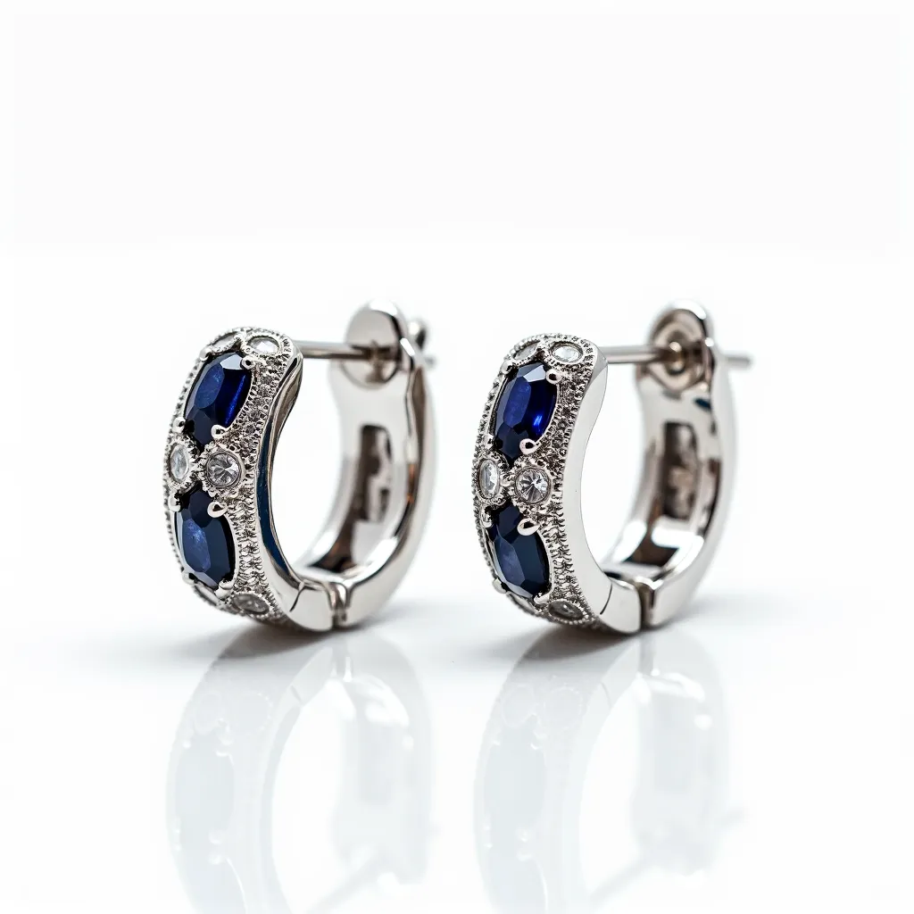 These silver huggie earrings feature a sleek and polished design crafted from sterling silver. Embellished with deep blue, marquise-cut gems, likely sapphires, the earrings exude an elegant appeal. Interspersed between the blue stones are small round-cut clear stones, possibly diamonds or cubic zirconia, creating a striking contrast and enhancing the overall brilliance. The stones are secured in prong settings, adding to the sophisticated design. These earrings are equipped with a latch-back clasp, ensuring a secure and comfortable fit.