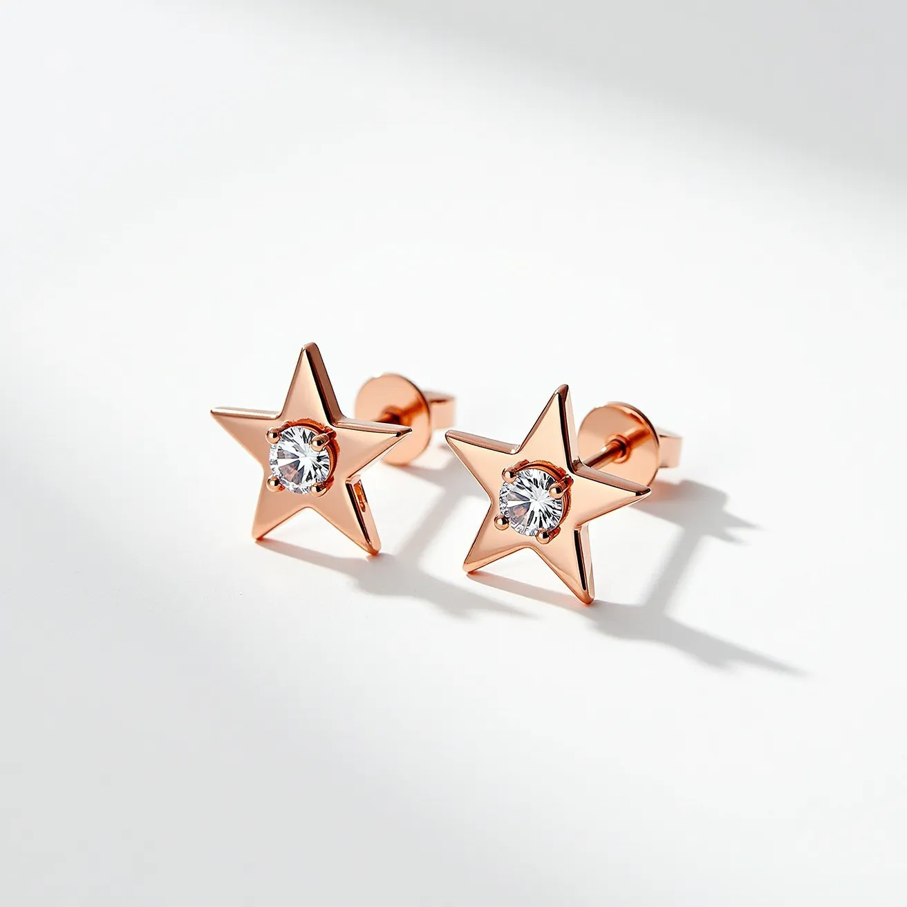 These star stud earrings feature a captivating design with a rose gold-tone metal forming the star shape. At the center of each star is a round, brilliant-cut gemstone, likely a diamond or a diamond simulant, set in a prong setting that enhances its sparkle. The earrings are fitted with a post and push-back clasp, providing a secure fit for comfortable wear. The combination of materials and design elements contributes to an elegant yet playful accessory.