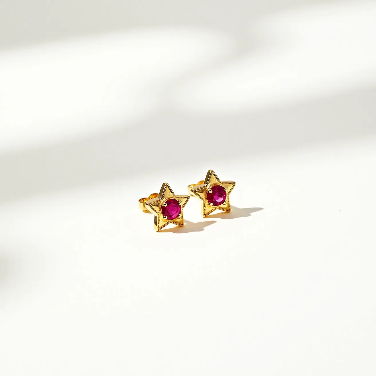 These star stud earrings feature a gold-toned metal shaped into a star design, which serves as the central motif. At the heart of each star is a brilliant red gemstone, cut into a round shape and secured using a bezel setting that showcases the gem while ensuring its stability. The studs are designed with a push-back clasp, making them easy to wear and secure. The combination of the vibrant red stones against the gold-toned metal offers a classic and elegant aesthetic.