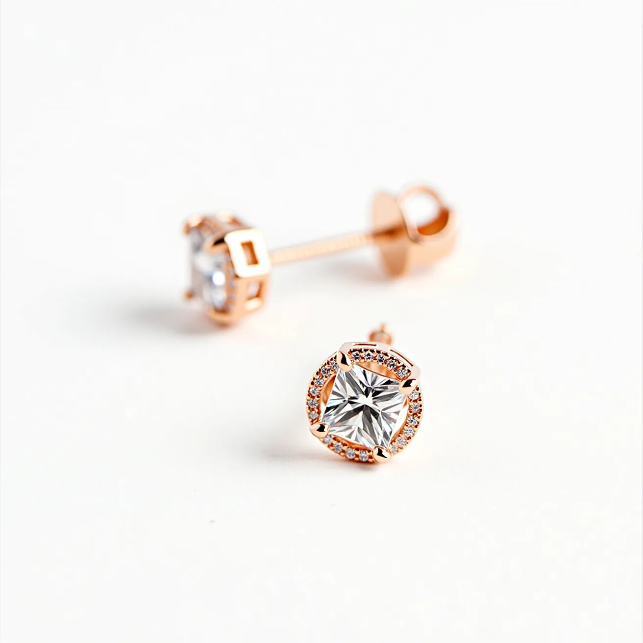 These stud earrings feature a prominent, radiant-cut central gemstone, likely a diamond or a high-quality crystal, enclosed in a rose gold setting that highlights the brilliance of the central stone. Surrounding the centerpiece is a halo of smaller, round-cut stones adding an extra layer of sparkle and elegance. The stones are securely held in place by a four-prong setting, which ensures that they remain prominently displayed. The earrings are equipped with a screw-back post, providing a secure and comfortable fit. The combination of rose gold and shimmering stones gives the earrings a classic yet contemporary appeal.