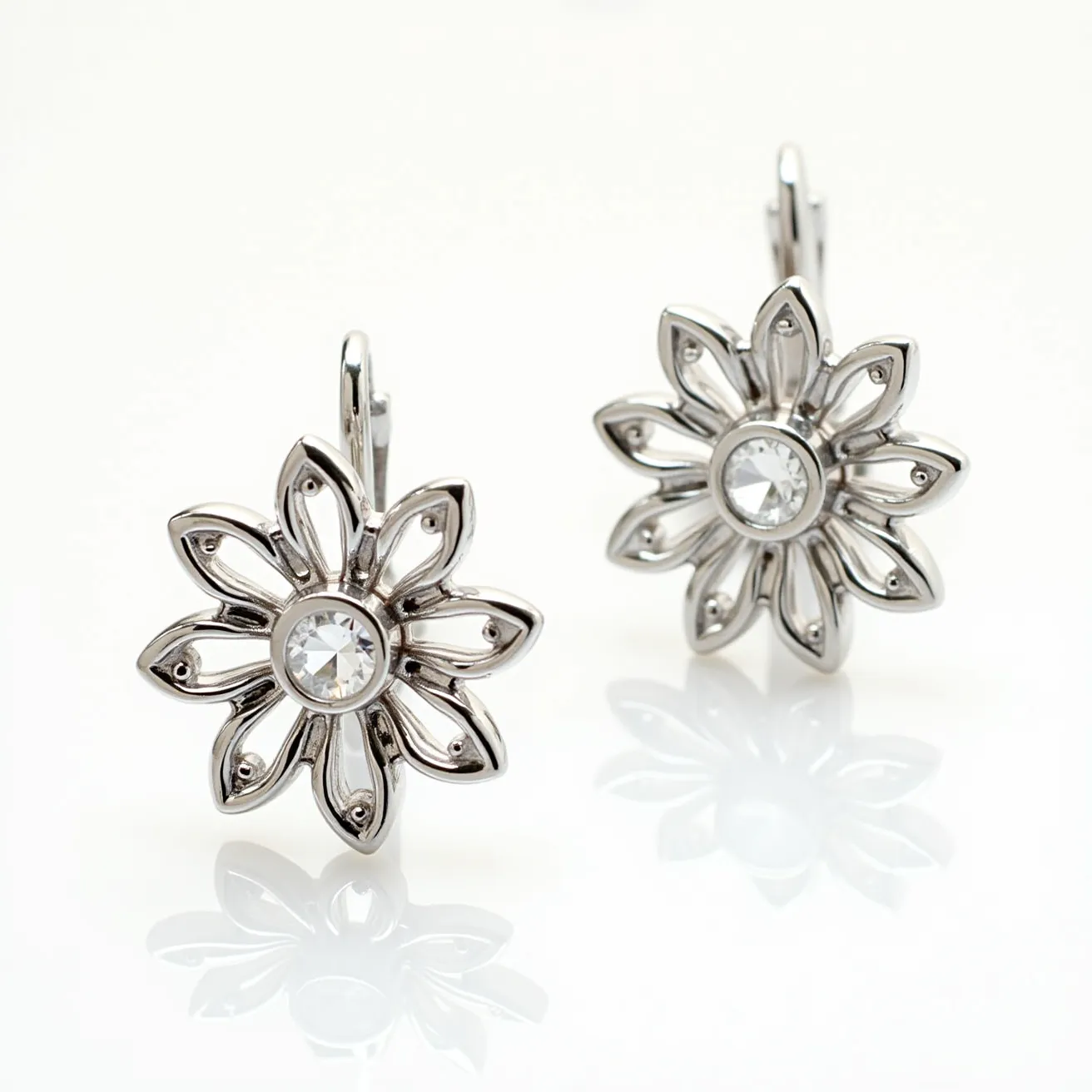 These sunflower earrings are crafted from a shiny metal resembling silver, designed to emulate the shape of a sunflower with detailed petal work. Each earring features a central round-cut gem that resembles a clear crystal or gemstone, possibly set in a bezel setting to keep it secure and enhance its brilliance. The cut of the stone allows for maximum light reflection, giving it an elegant and sparkling appearance. The earrings are equipped with a lever-back clasp, providing a secure and comfortable attachment while ensuring they hang gracefully from the ears.