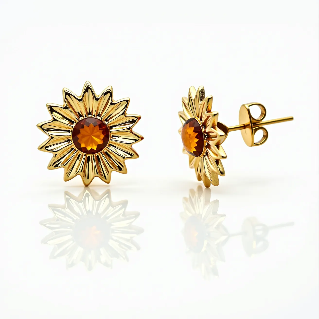 These sunflower earrings feature a design crafted from gold-toned metal, elegantly shaped into the form of sunflower petals radiating outward. At the center, a prominent gemstone with a rich amber hue adds a striking focal point, cut in a multifaceted round shape to enhance its brilliance. The stone is securely set within a bezel setting, providing both stability and a seamless appearance. These earrings utilize a post and butterfly clutch back, ensuring a secure and comfortable fit when worn. The harmonious combination of the sunflower motif and the central gem gives these earrings a vibrant and stylish look.