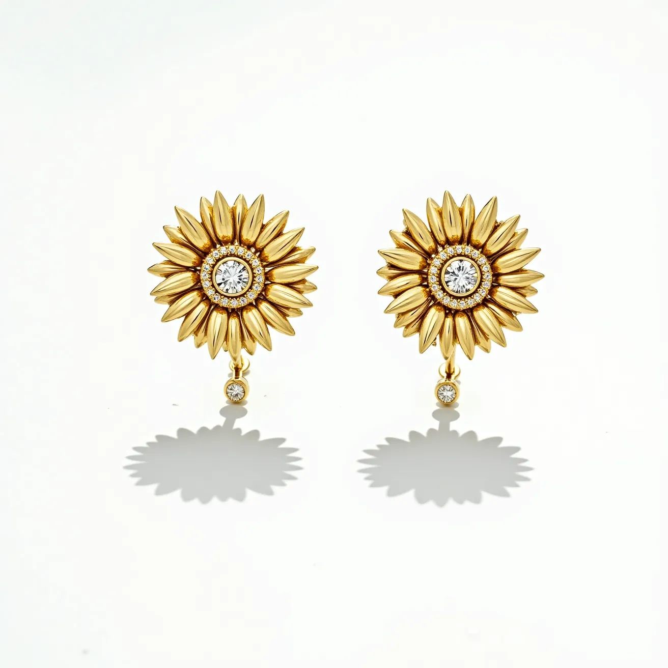 These sunflower earrings are crafted with a gold-colored metal, forming a detailed sunflower motif. At the center of each sunflower is a round, brilliant-cut clear gemstone, likely set in a bezel or prong setting that enhances its sparkle. Surrounding the central stone are smaller, equally brilliant stones, adding depth and radiance to the design. Dangling from each earring is an additional clear stone, complementing the central gemstone and providing movement. These earrings are designed for pierced ears, likely featuring a post or lever-back clasp for secure attachment.