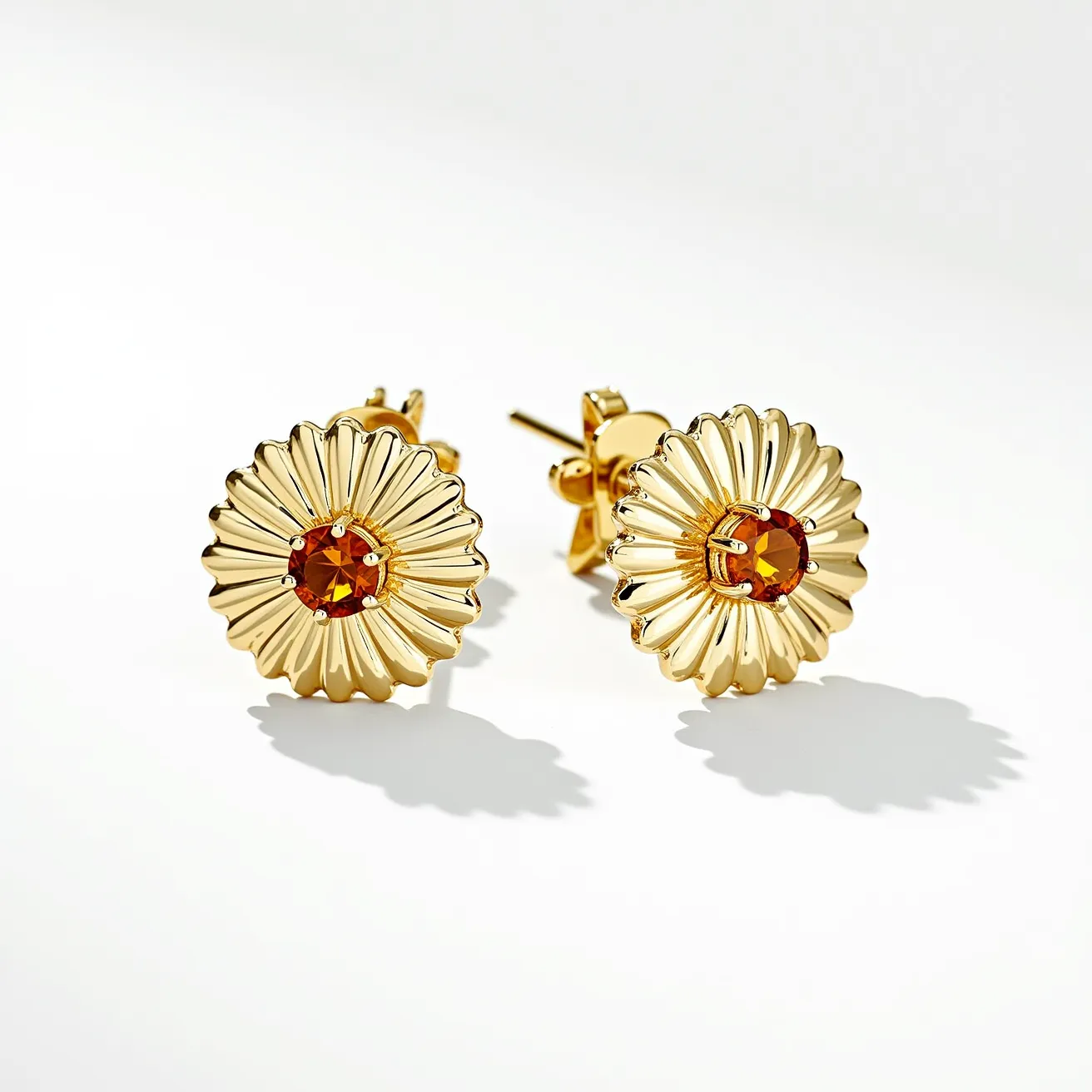 These sunflower earrings feature a delightful design with a gold-tone metal forming the petals of the sunflower, intricately crafted to mimic the natural beauty of the flower. At the center of each earring is a round-cut gem, likely a citrine, set in a prong setting that enhances its warm, amber hue and sparkling brilliance. The earrings are designed as studs, with a post and butterfly clutch back, providing a secure and comfortable fit for the wearer.