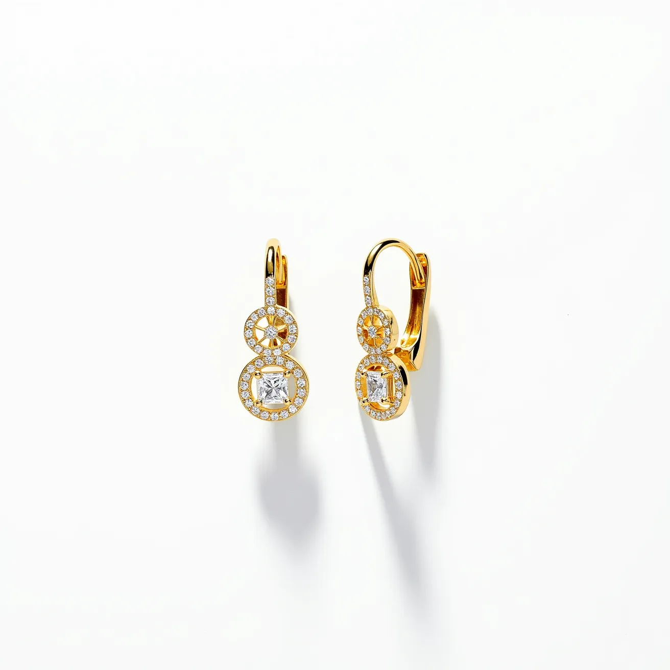 These teacher earrings feature an elegant design crafted from gold, showcasing two connected circular elements. The top circle of each earring is adorned with small, round-cut clear stones set in a pavé style, creating a sparkling halo. The bottom circle houses a larger, square-cut stone in a bezel setting, adding a striking focal point to the piece. The earrings are equipped with a lever-back clasp, ensuring a secure and comfortable fit. The combination of these elements results in a sophisticated and timeless accessory.