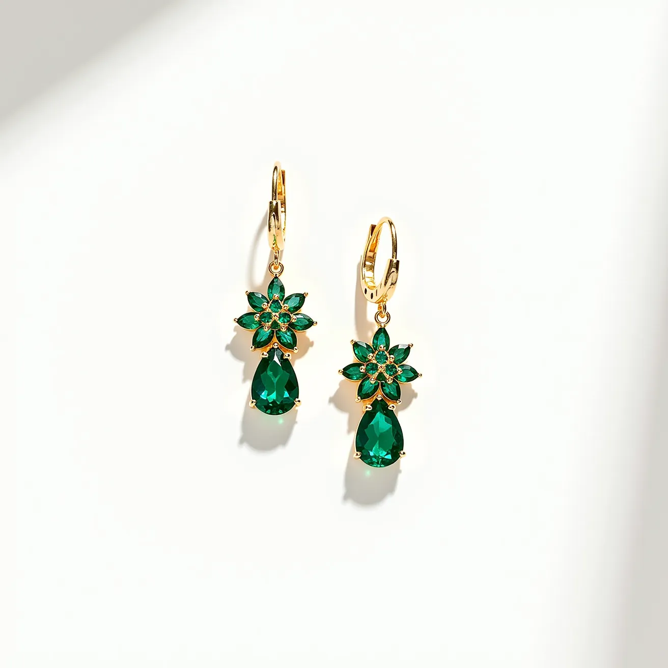 These teal earrings feature a sophisticated design, showcasing a teardrop-shaped teal gemstone that is beautifully faceted to catch the light. Attached to a gold setting, the teardrop stone dangles elegantly below a floral cluster of smaller round and marquise-cut teal stones, adding an intricate and ornate appeal. The earrings use a lever-back clasp, providing a secure fit while adding to the overall aesthetic with its polished and gleaming gold finish. The floral motif enhances the earrings' elegance, making them a suitable accessory for both formal and casual occasions.