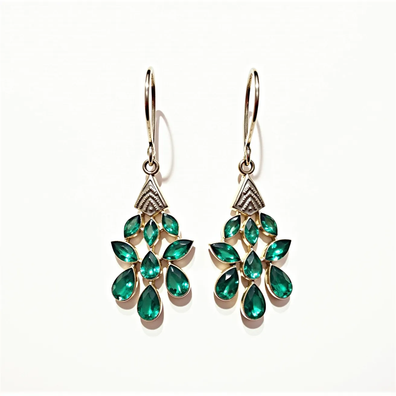 These teal earrings feature a striking design composed of multiple pear-shaped gems, likely made from a stone that closely resembles emeralds, arranged in a cascading pattern. The stones are cut to catch light beautifully, each set in a gold-toned metal that enhances their vibrant color. The earrings hang from elegant, slender hooks through a loop, providing a secure and comfortable fit. An eye-catching triangular motif sits above the main arrangement, adding a geometric element to the design. The craftsmanship highlights the vivid hue and brilliance of the stones, making them a standout accessory.