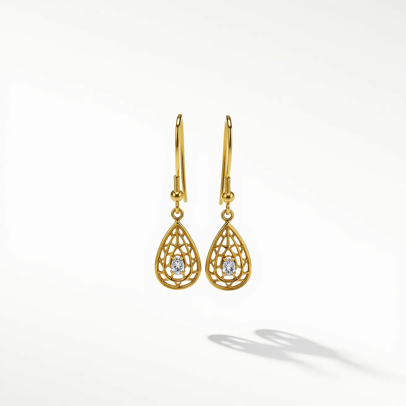 These teardrop earrings feature an intricate gold lattice design that highlights a central clear gemstone, likely a diamond or a diamond-like stone, which appears in a brilliant cut to maximize its sparkle. The gemstone is securely held within the gold design using a prong setting, allowing it to catch light from multiple angles. The earrings are suspended from simple, elegant hook clasps that provide both ease of wear and security. The overall design combines classic elegance with a touch of modern sophistication, making them a versatile accessory for various occasions.