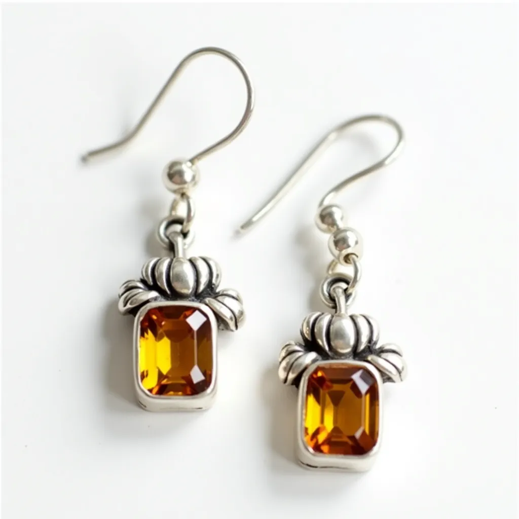 These thanksgiving earrings feature a charming and festive design highlighted by the presence of an amber-colored stone, cut in an emerald shape, set securely within a metal bezel setting. The metal, likely silver-toned, beautifully complements the warm hue of the stone and is intricately designed to resemble a pumpkin motif above the stone, adding to the holiday theme. The earrings are fitted with a classic fishhook clasp or attachment, ensuring a comfortable and secure fit for the wearer. The combination of the earthy color palette and thematic design makes these earrings an ideal accessory for the Thanksgiving season.