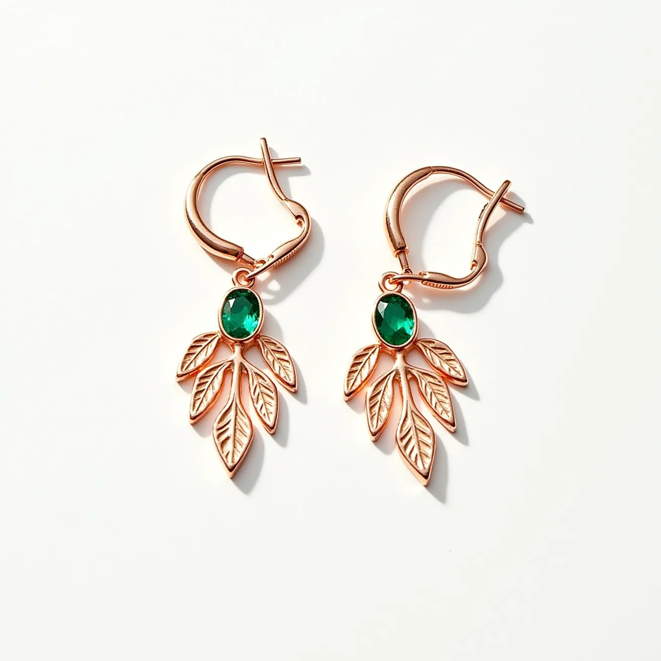 These thanksgiving earrings feature a charming design with a rose gold-toned metal serving as the primary material. Each earring is adorned with an oval-cut green stone, set gracefully in a claw setting that holds it securely while allowing light to enhance its color. The stone is surrounded by an intricate arrangement of leaf-shaped metal charms, adding a festive and organic touch. The clasp mechanism is a lever-back style, providing both security and ease of wear, making these earrings perfect for a seasonal celebration.